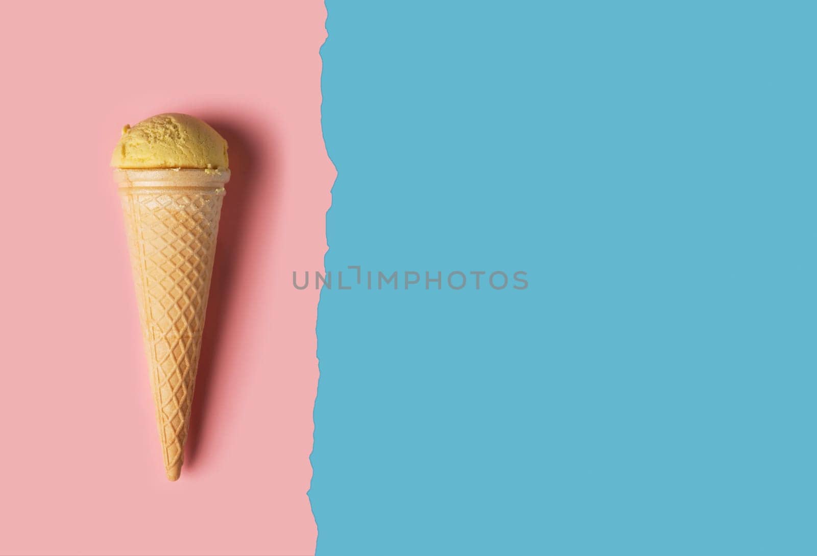Ice cream with wafer cone on pink and blue background. Top view flat lay with copy space composition