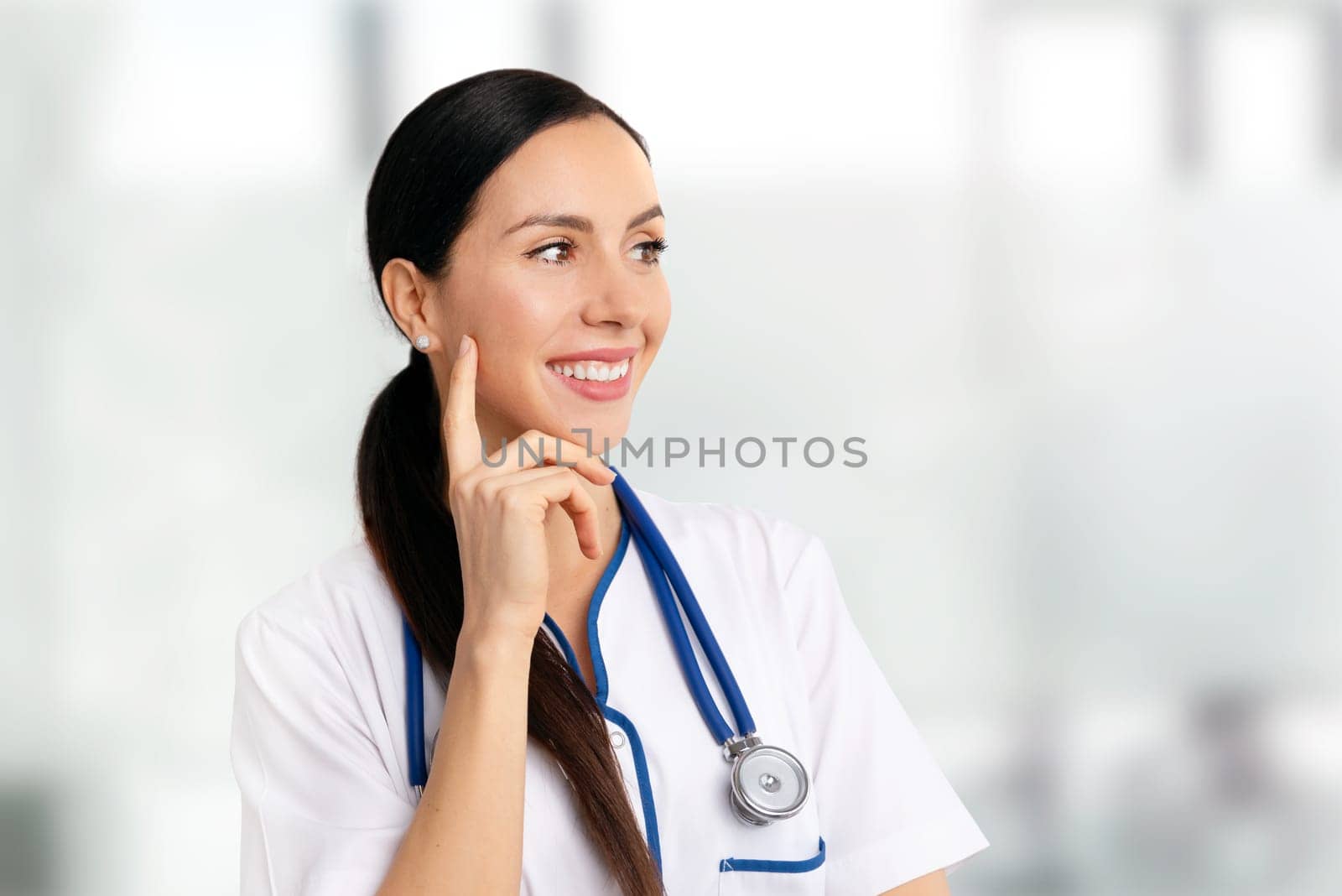Portrait of a beautiful female doctor. Smiling woman with stethoscope