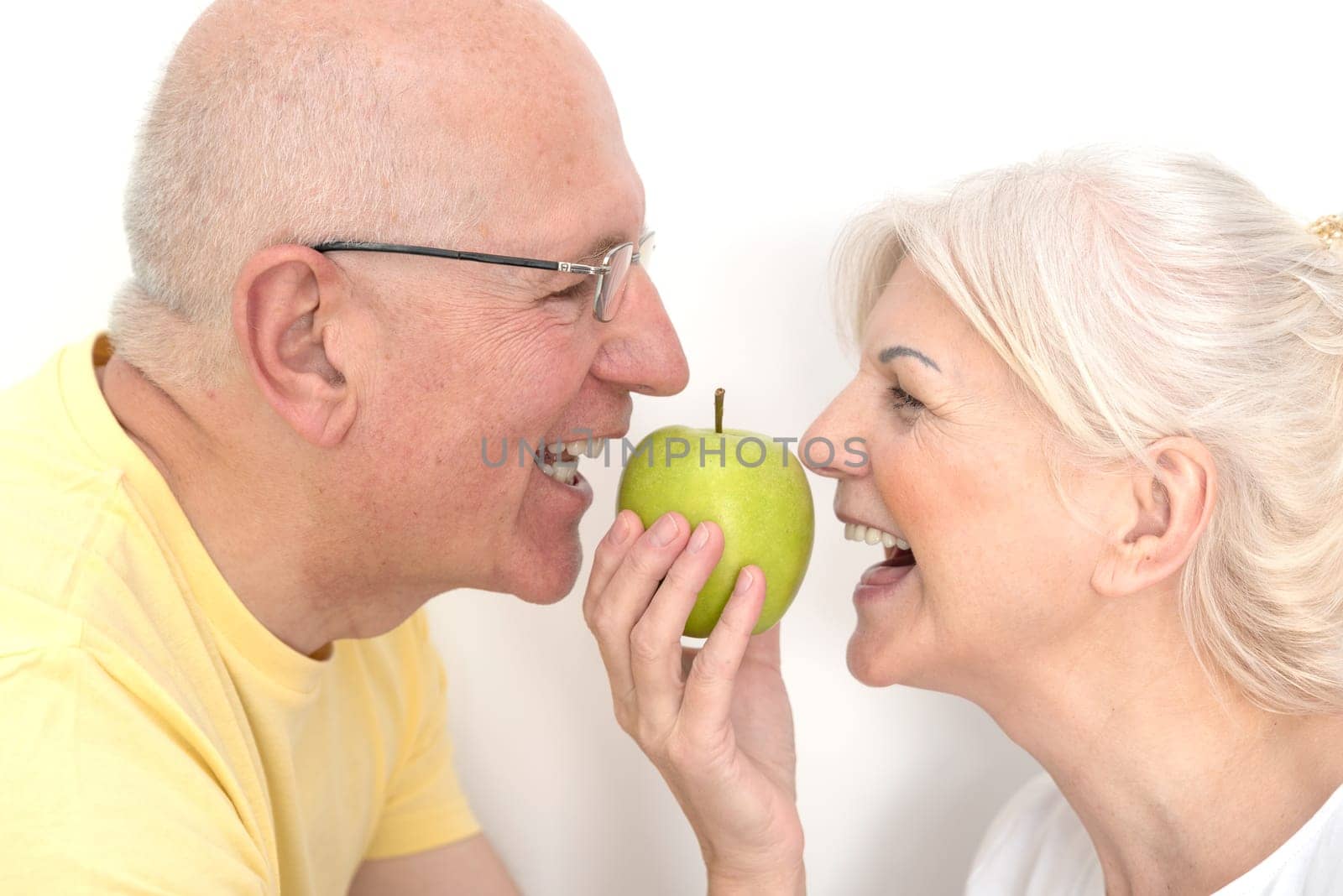Senior couple with apple, healthy teeth concept by simpson33