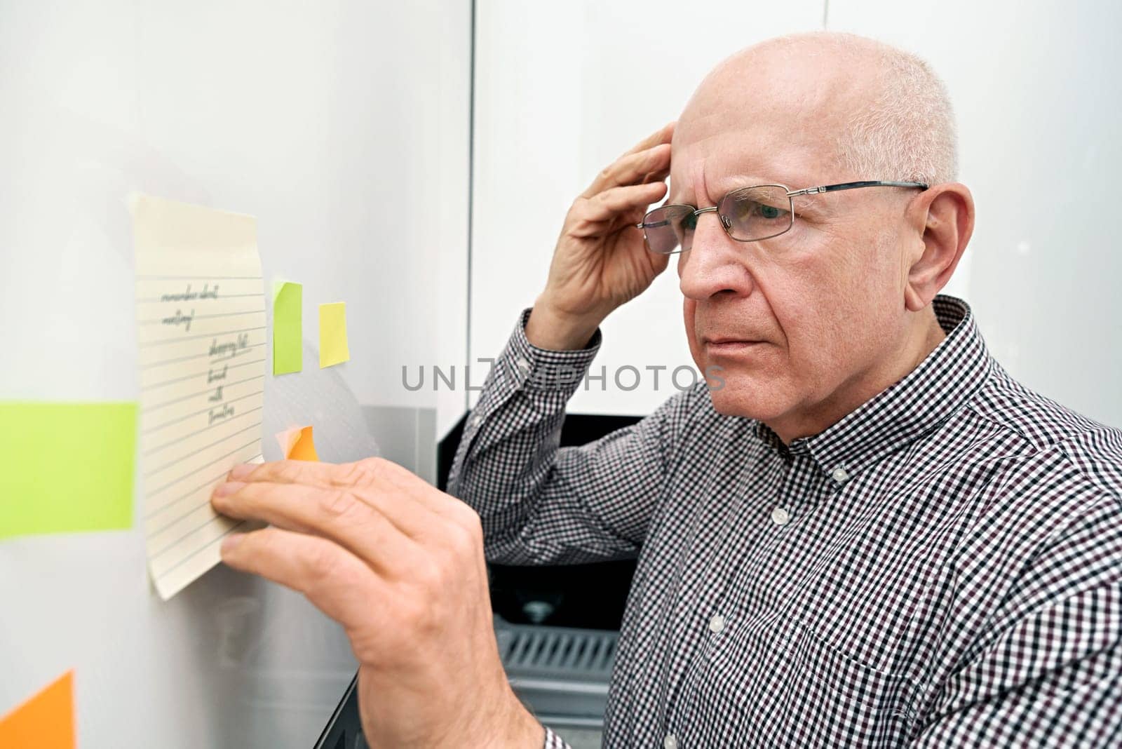 Elderly man with dementia looking at notes by simpson33