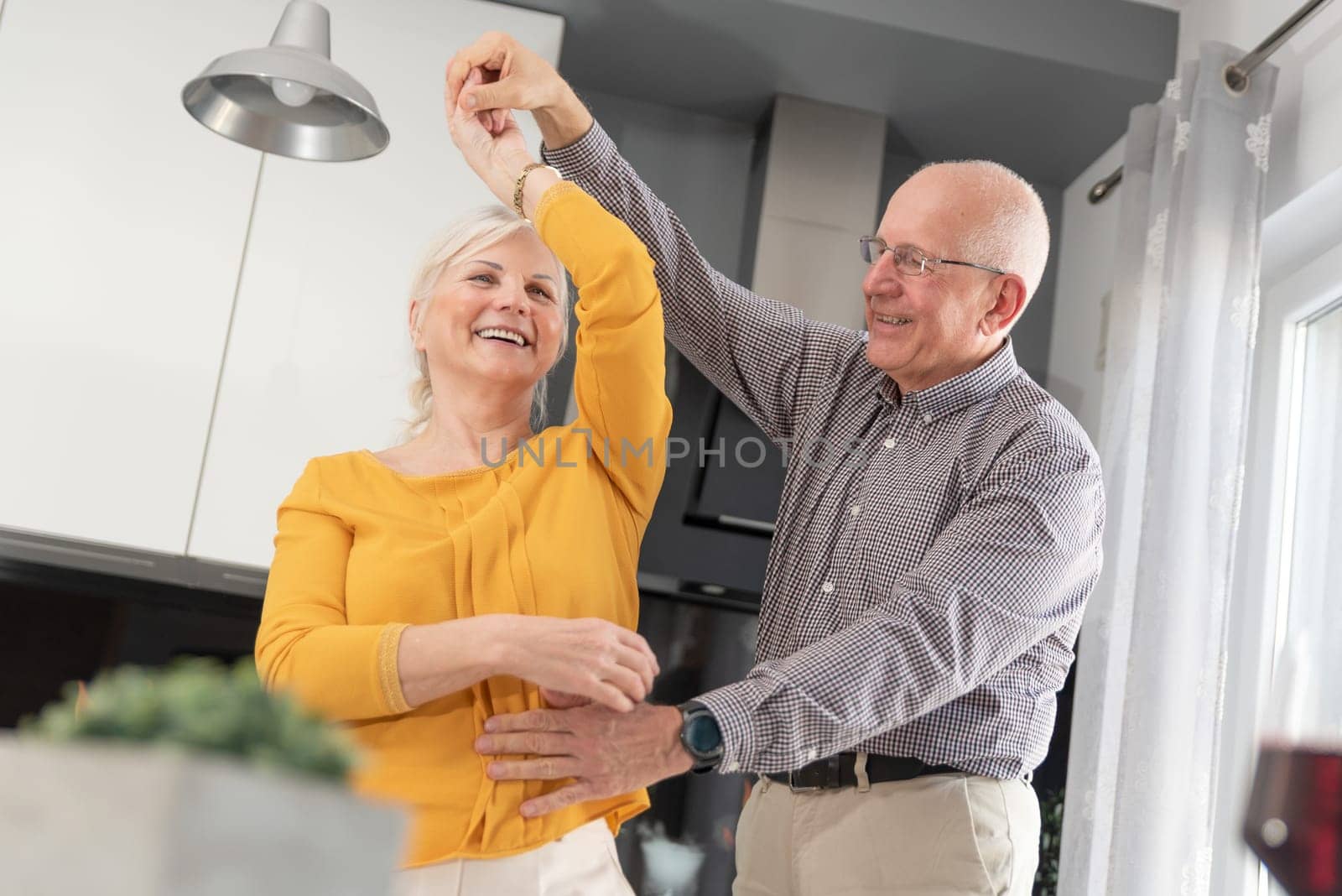 Senior couple dancing and smiling at home. Happy couple of pensioners