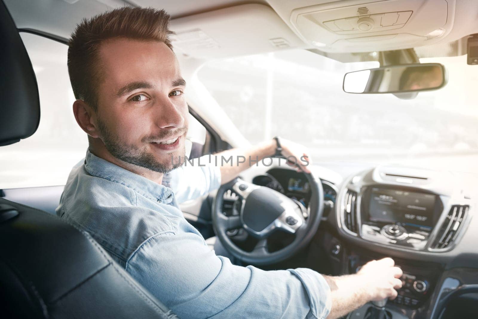 Young male driver behind the wheel. Sharing economy service or taxi driver concept