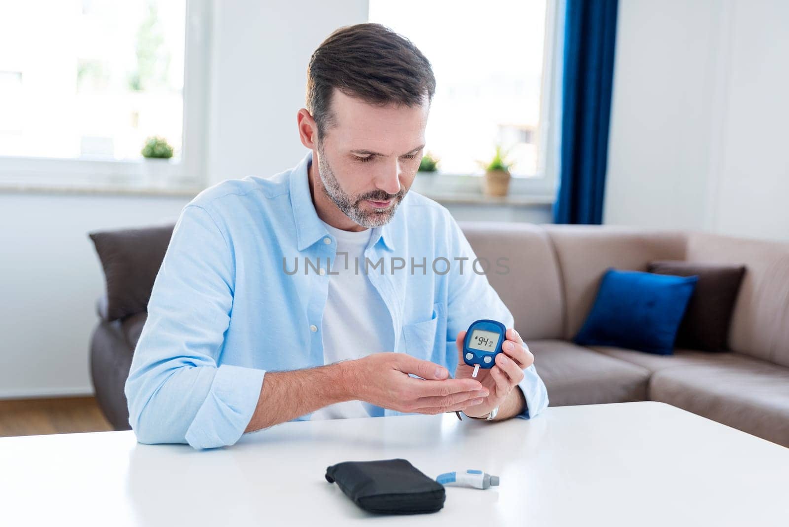 Man measures his blood sugar. Glucometer, blood sample test, diabetes concept.