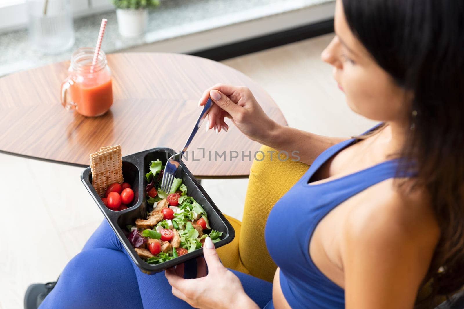 Fit woman eating healthy food at home. Healthy lifestyle concept with fitness catering