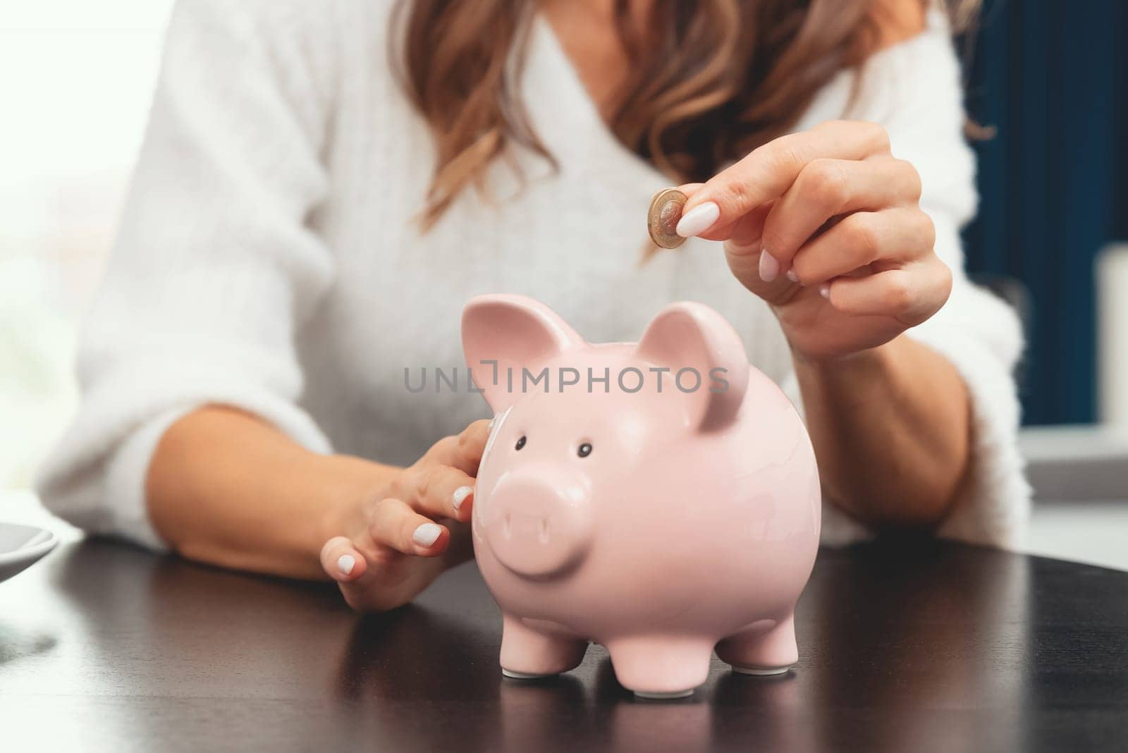 Woman putting coin into piggy bank. by simpson33