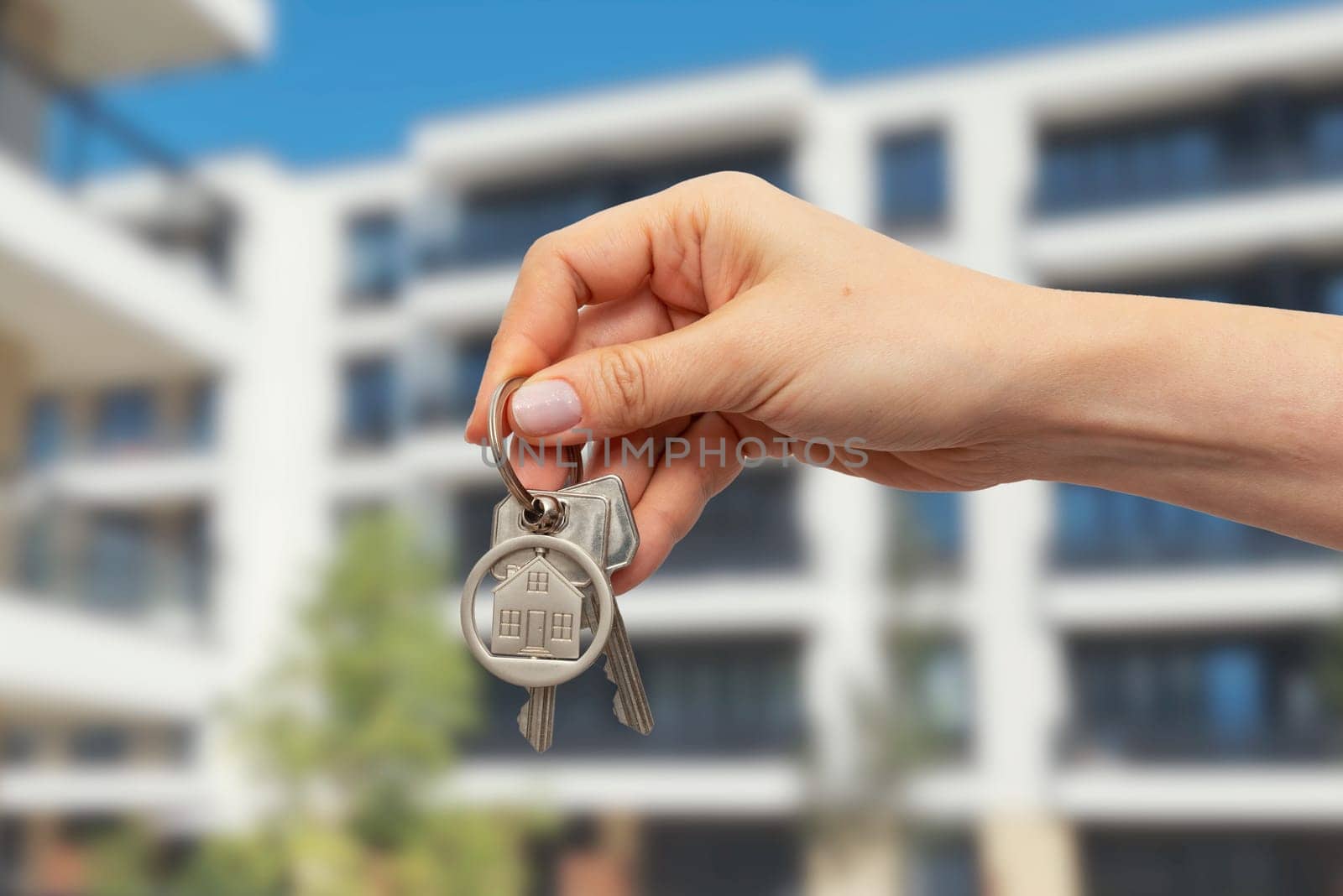 Real estate concept with home keys in hand. Hand holding keychain