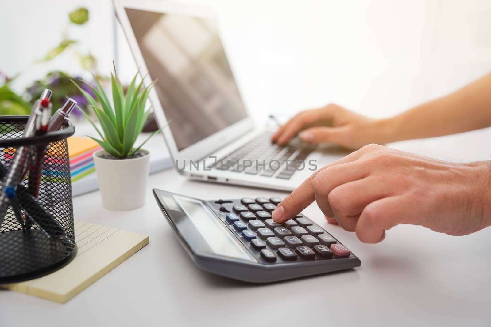 Business man using calculator with computer laptop by simpson33