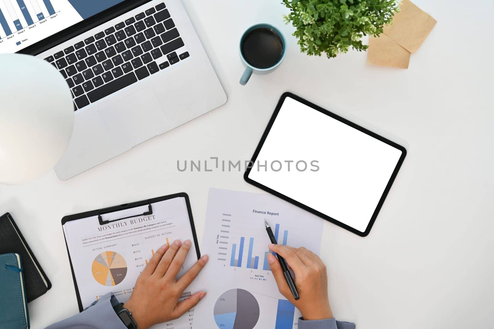 Businesswoman analyzing statistics, working with financial graphs charts on white office desk.