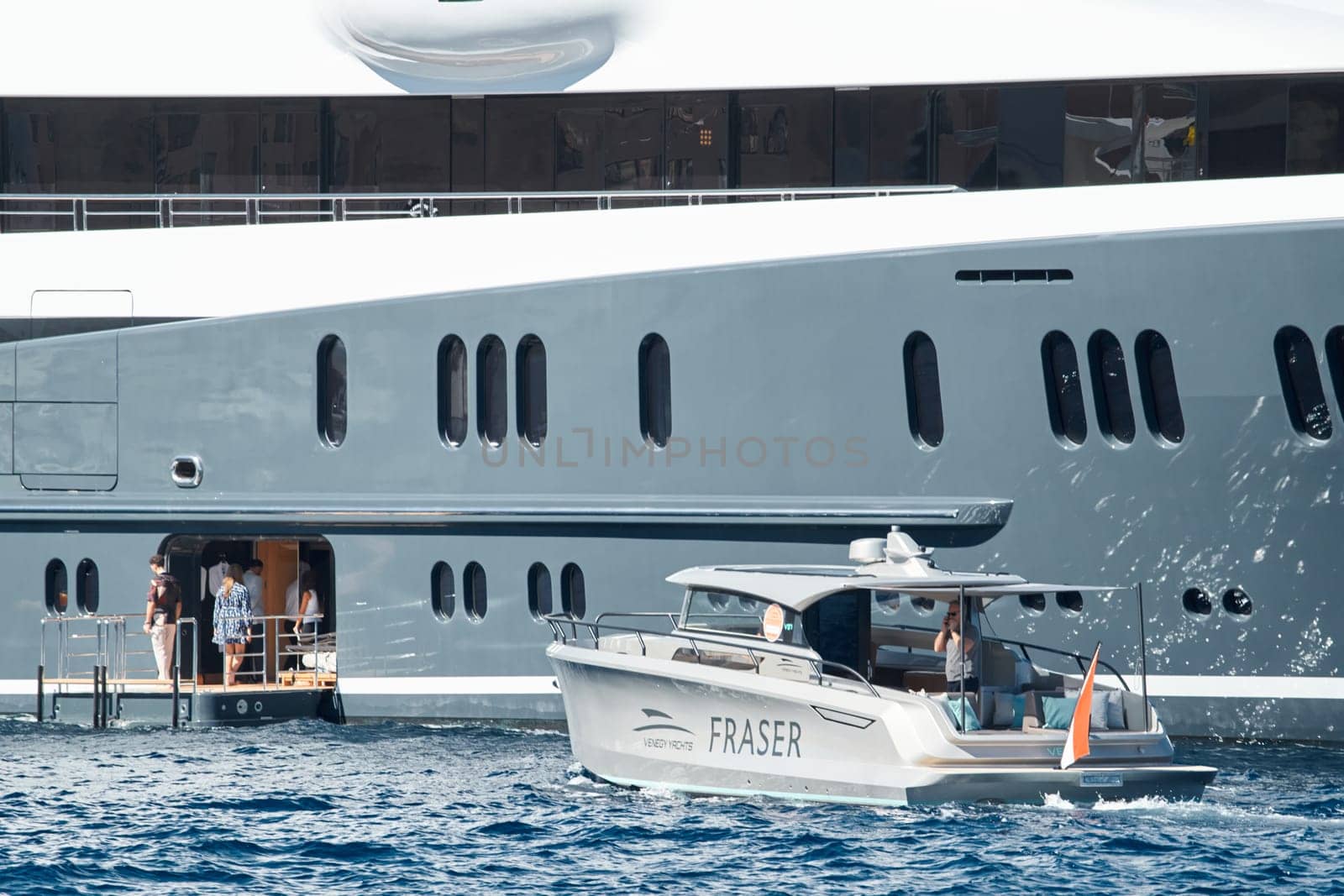 Monaco, Monte Carlo, 27 September 2022 - Invited wealthy clients inspect megayachts at the largest fair exhibition in the world yacht show MYS, port Hercules, yacht brokers, sunny weather. High quality photo