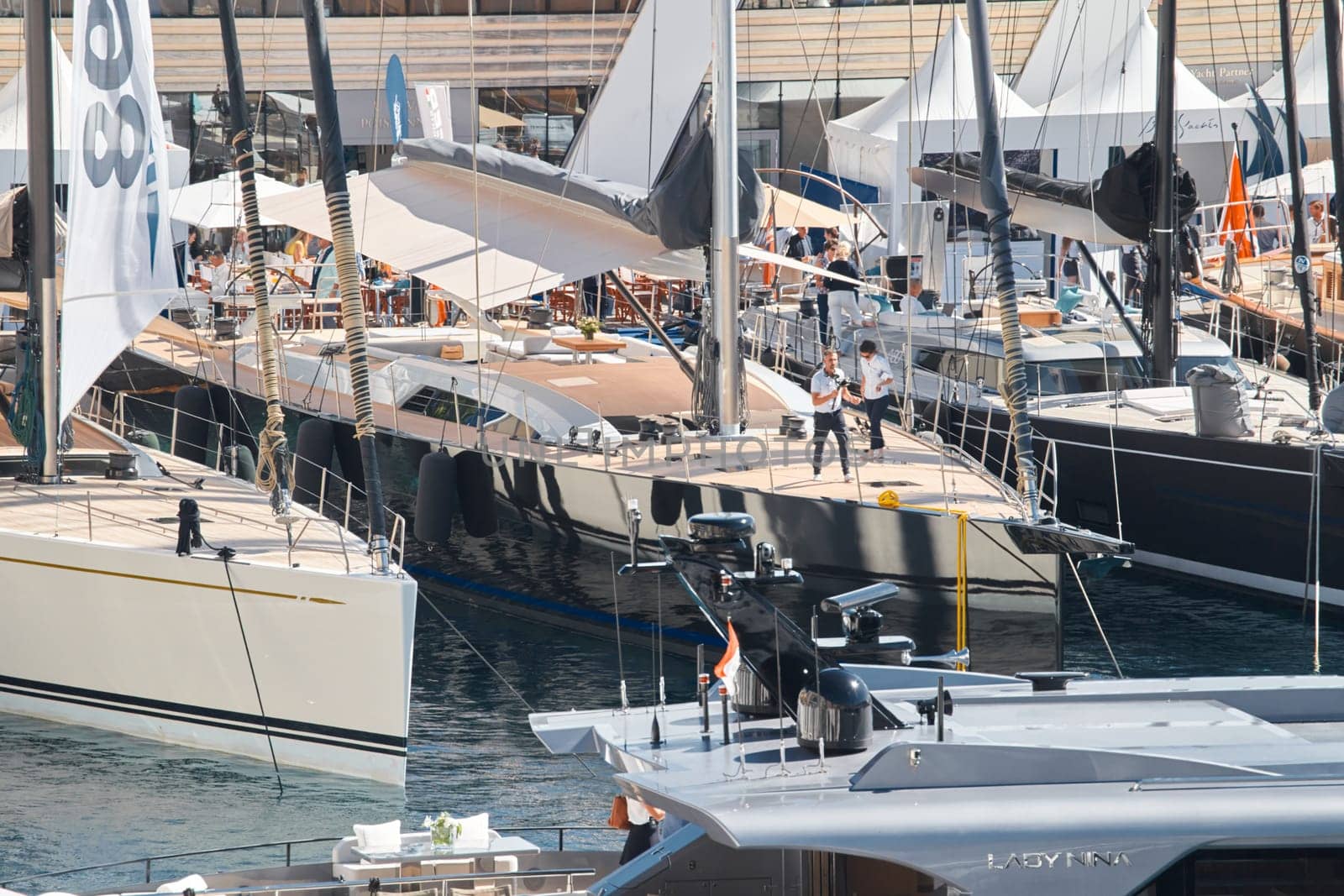 Monaco, Monte Carlo, 27 September 2022 - Invited wealthy clients inspect megayachts at the largest fair exhibition in the world yacht show MYS, port Hercules, yacht brokers, sunny weather. High quality photo