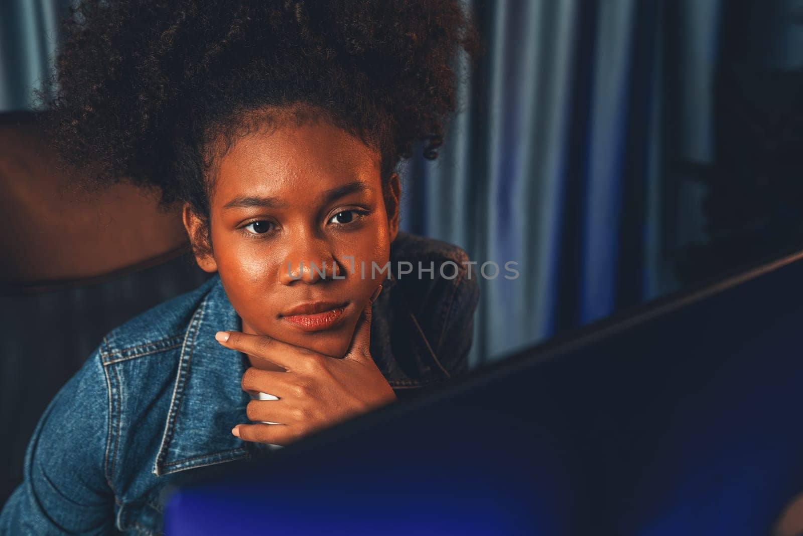 African woman with serious face, focusing project on laptop. Tastemaker. by biancoblue