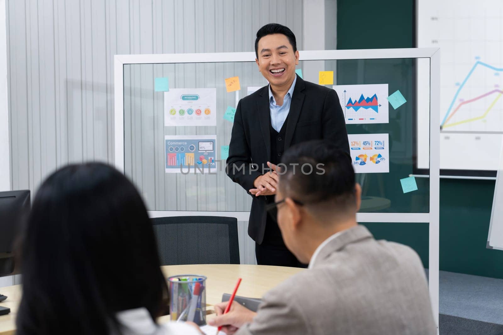 Successful businessman presenting his financial plan and data analyst with smiling face. Executive editors focus on his performance intentionally. Office Conference room meeting. Intellectual.