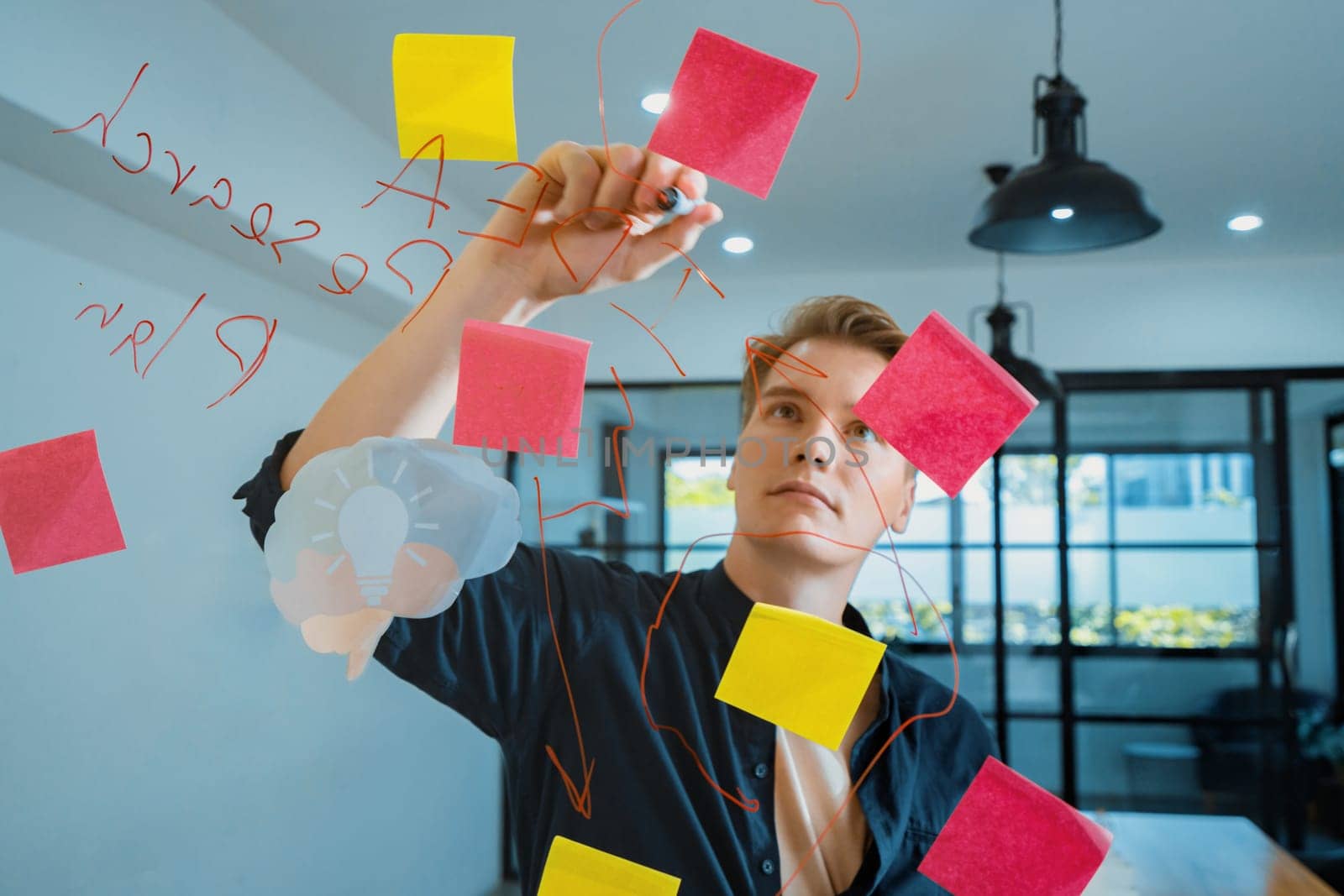 Professional caucasian businessman writing marketing idea by using mind map and sticky notes on glass board at modern meeting room. Creative business and planing concept. Closeup. Immaculate.