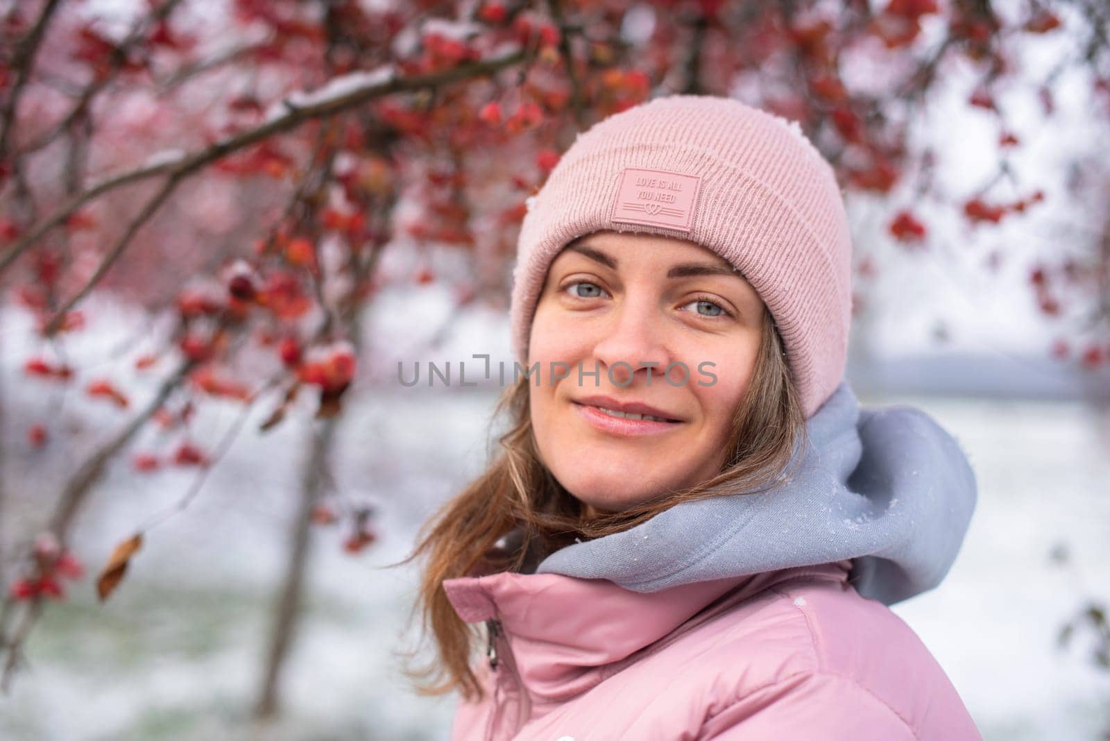 Winter lifestyle portrait of cheerful pretty girl. Smiling and having fun in the snow park. Snowflakes falling down. by Andrii_Ko