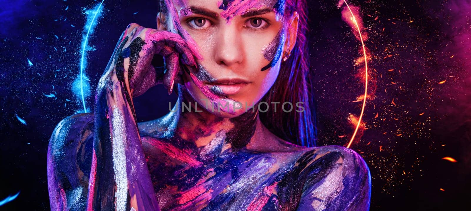 Woman in neon lights. Portrait of sexy dancer at club party. Body art with bodypaint.