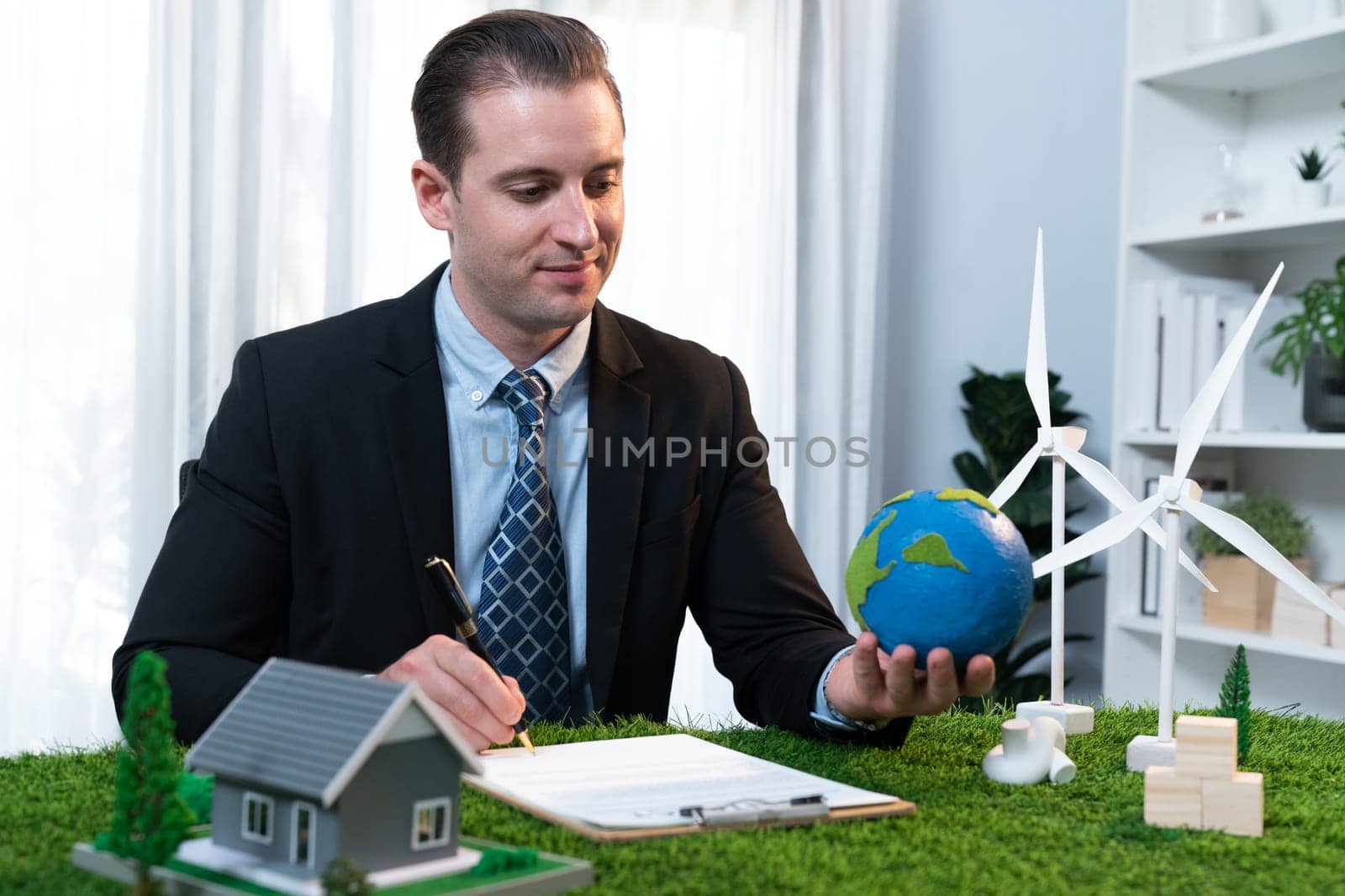 Businessman or CEO holding paper globe in office. Quaint by biancoblue