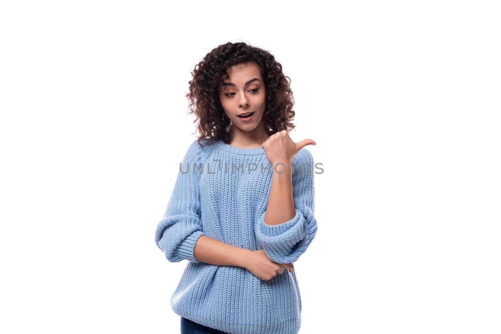 young curly brunette woman dressed in a blue sweater is brainstorming.
