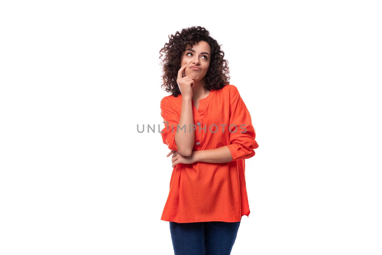 young tired caucasian lady with black curly hair dressed in an orange shirt thought by TRMK
