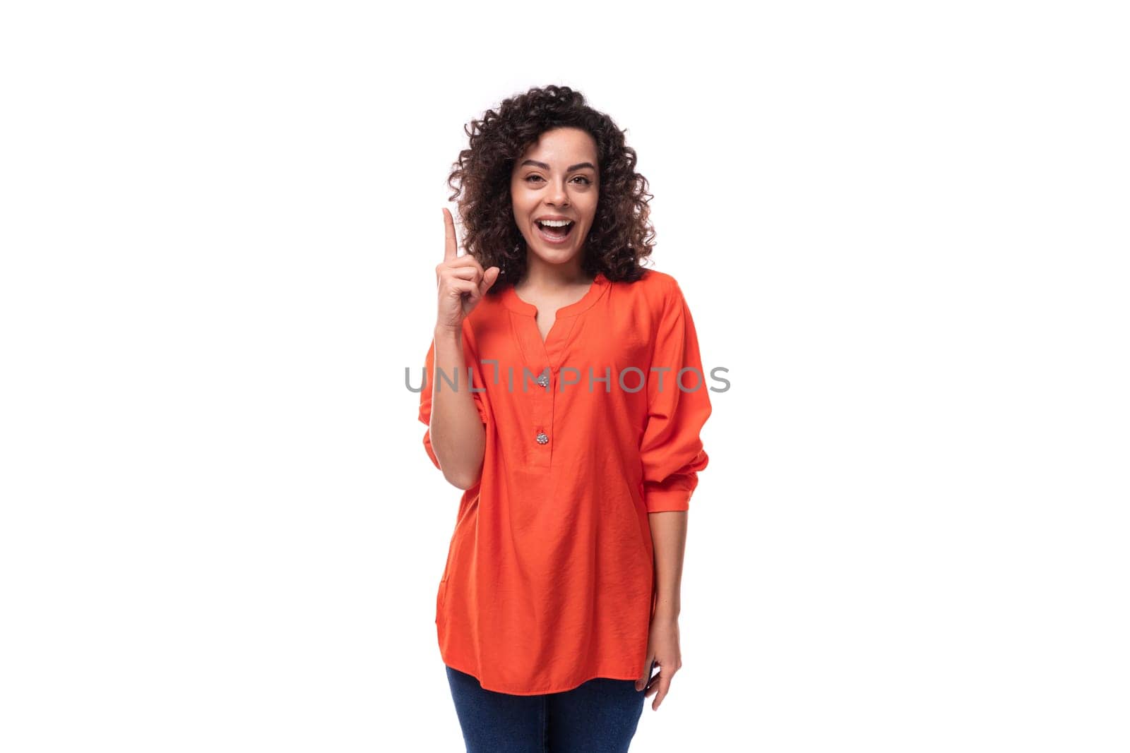 young dreamy caucasian business woman with wavy hair dressed in an orange blouse on a white background.