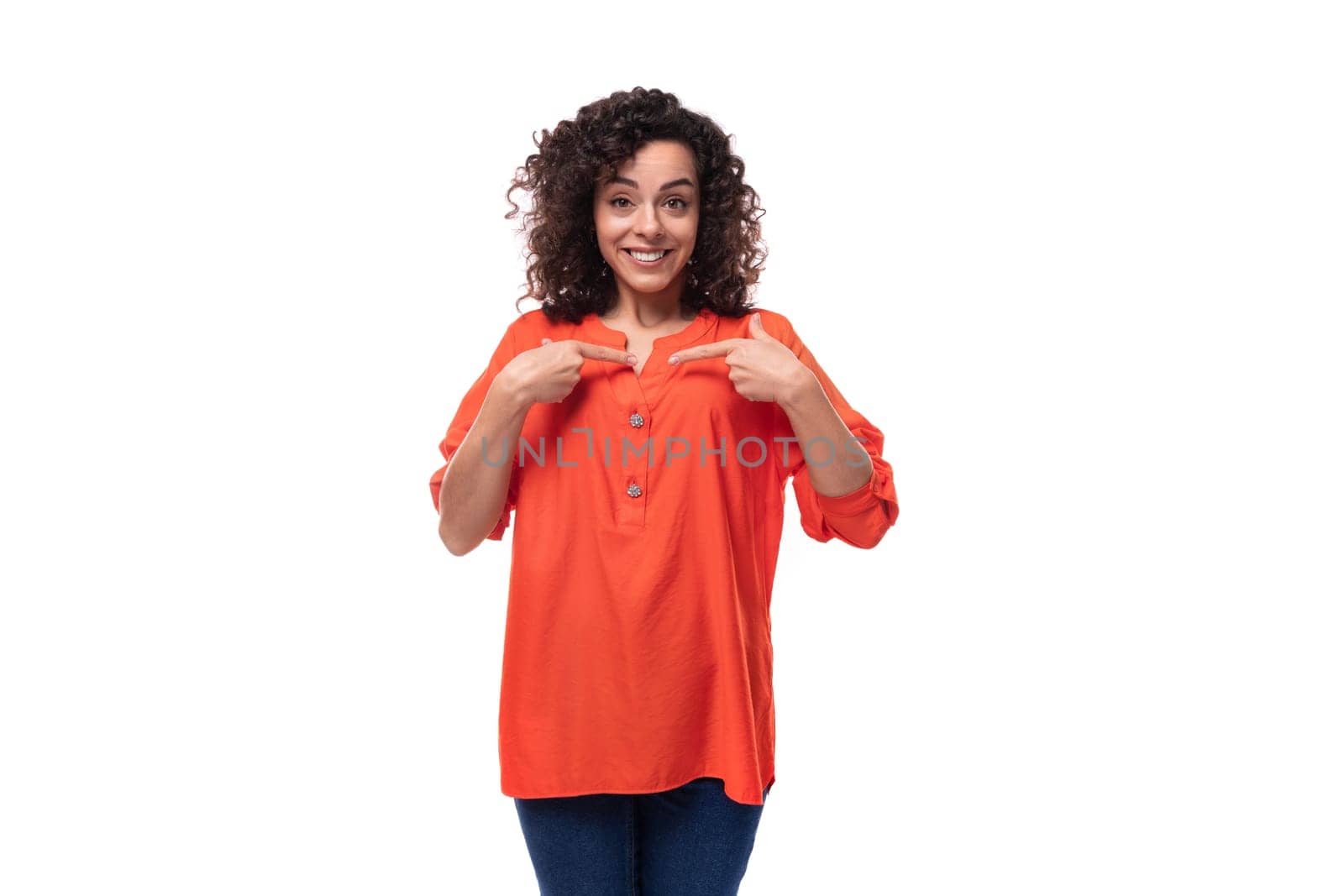 young curly brunette woman dressed in an orange blouse is inspired by an idea. brainstorming concept.