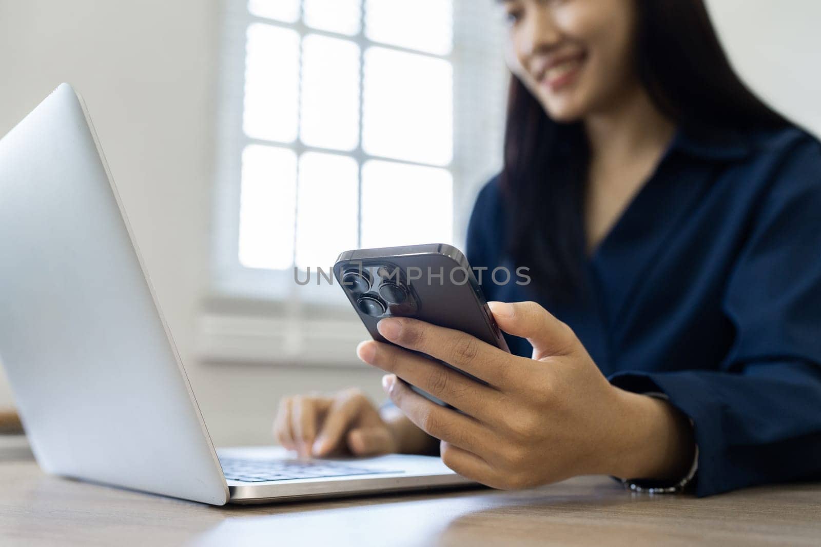 Young woman makes a financial transaction on the Internet on the laptop with mobile.