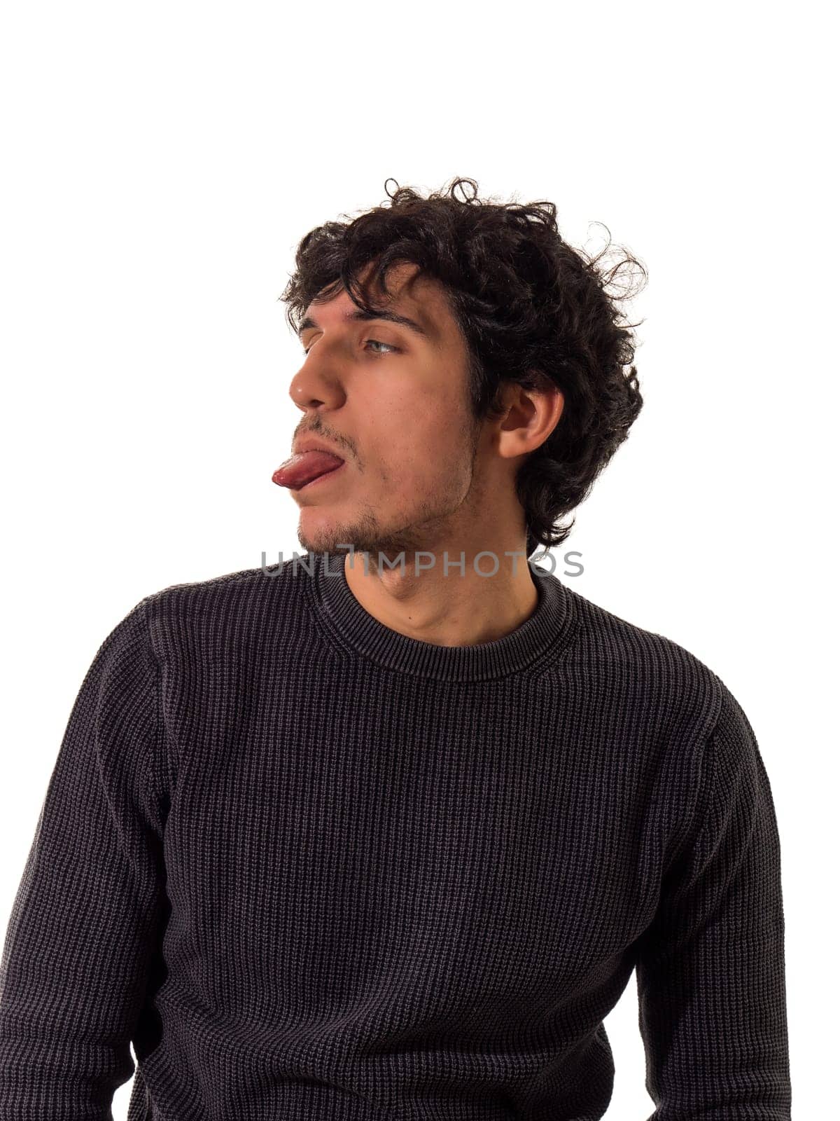 A man making a funny face while sitting down, sticking tongue out, isolated on white background