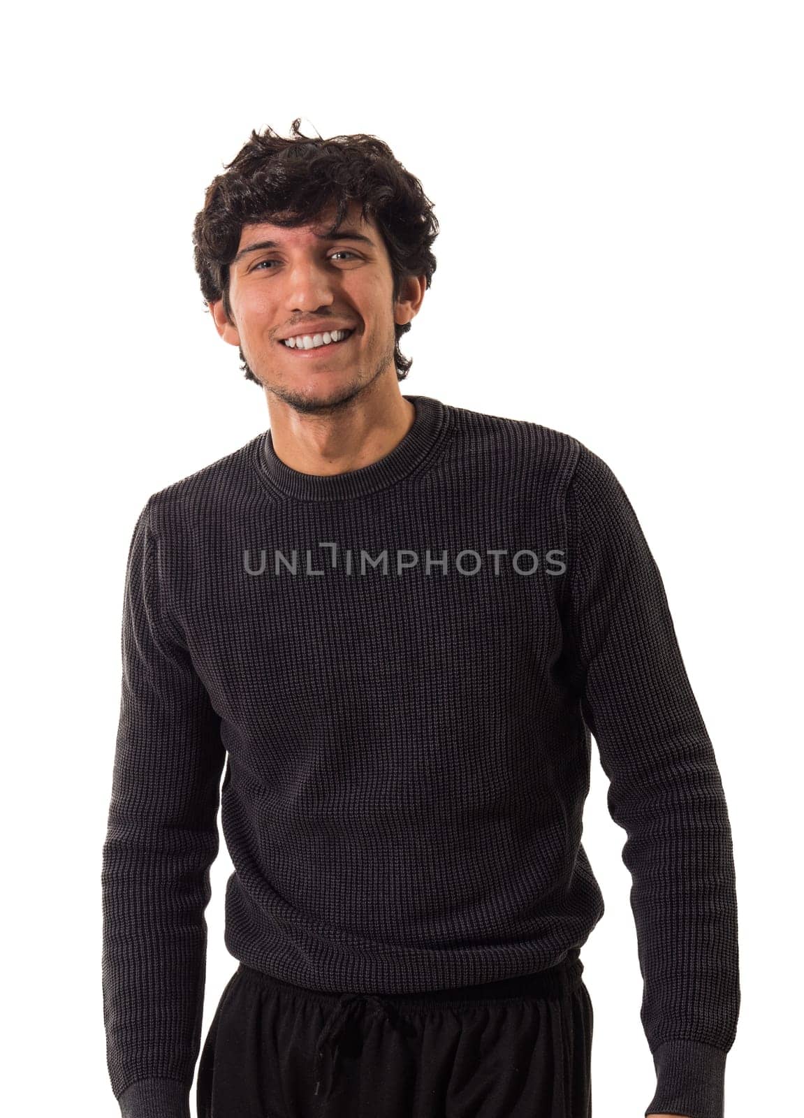 A young handsome man in a black sweater and black pants, smiling with a friendly expression to the camera