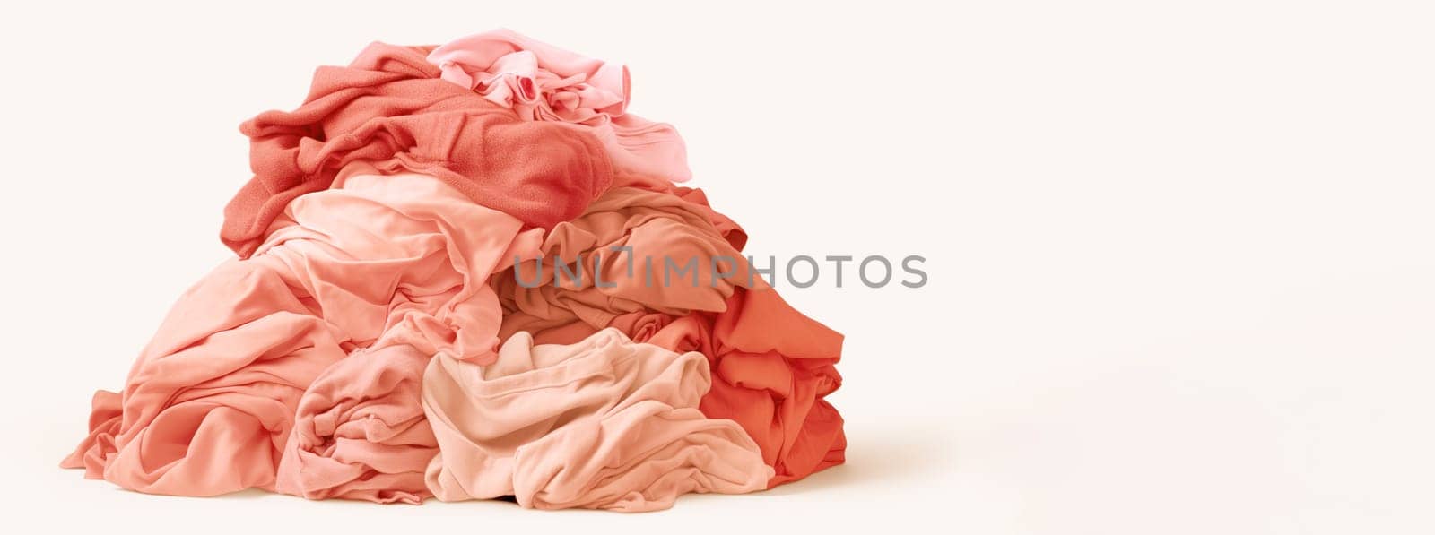 large stacks of pink colored clothes isolated on white background,sorted by color for gentle washing,used clothes,overproduction,trendy peach fuzz,color of the year 2024,copy space,High qualitu photo