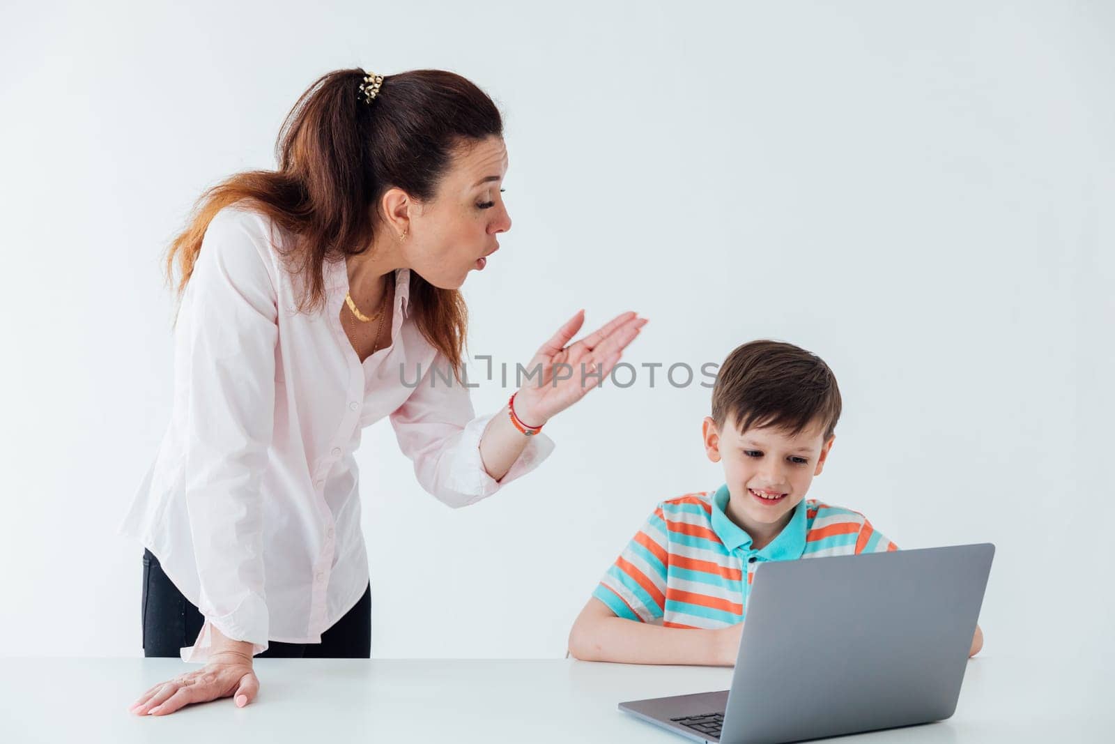 Woman teaching boy to work on computer online by Simakov