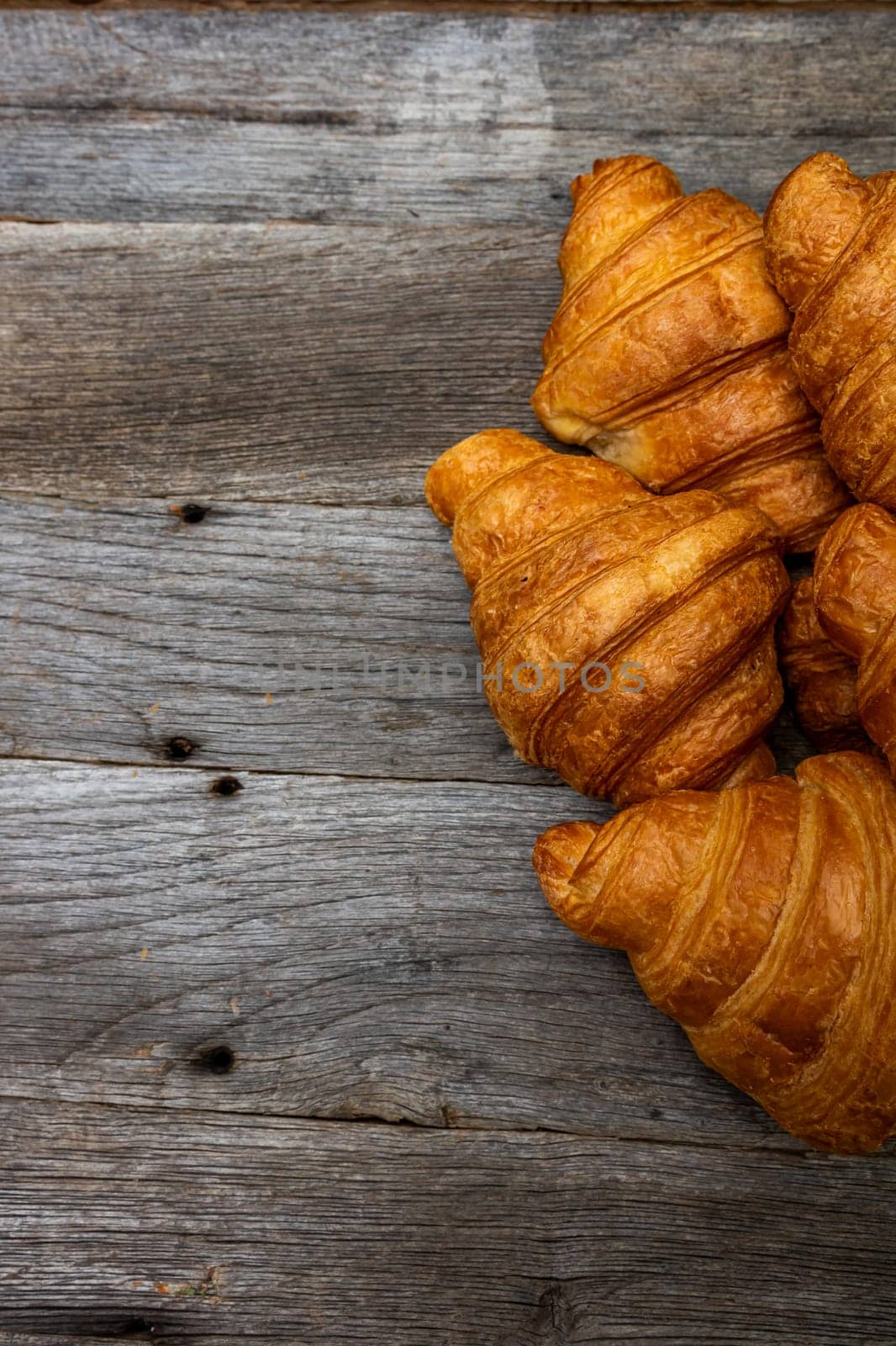 Delicious, fresh croissants isolated on wooden board. French breakfast concept. by vladispas