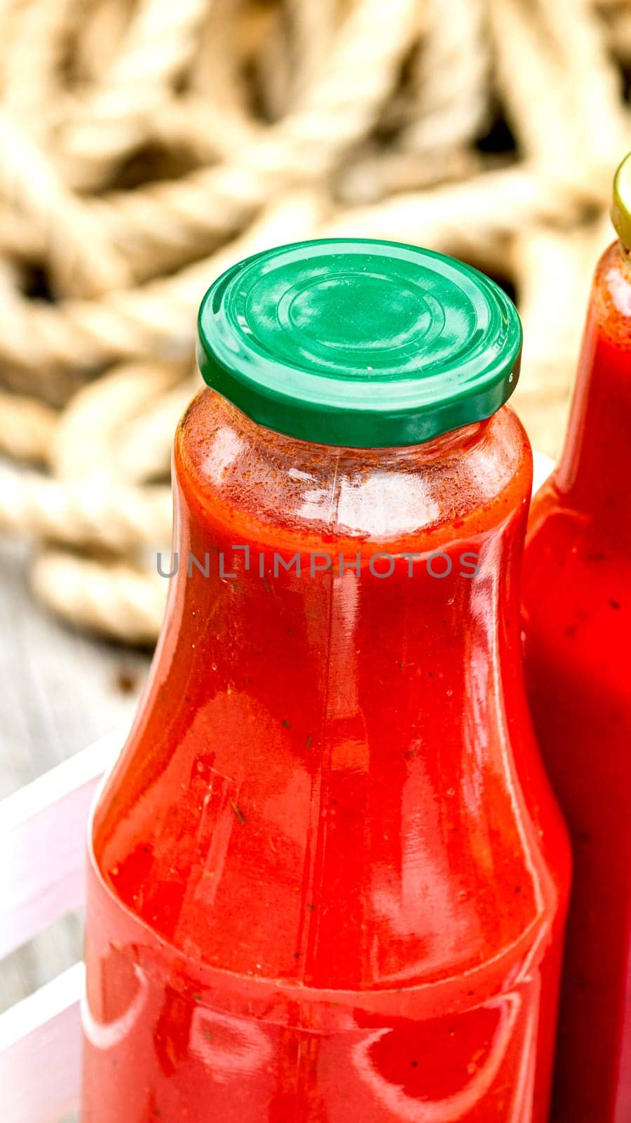Bottles of tomato sauce, preserved canned pickled food concept isolated in a rustic composition. by vladispas