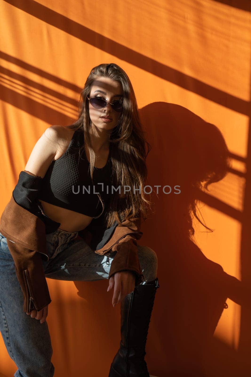 Beautiful fashionable woman and light and shadow from window blinds by Simakov