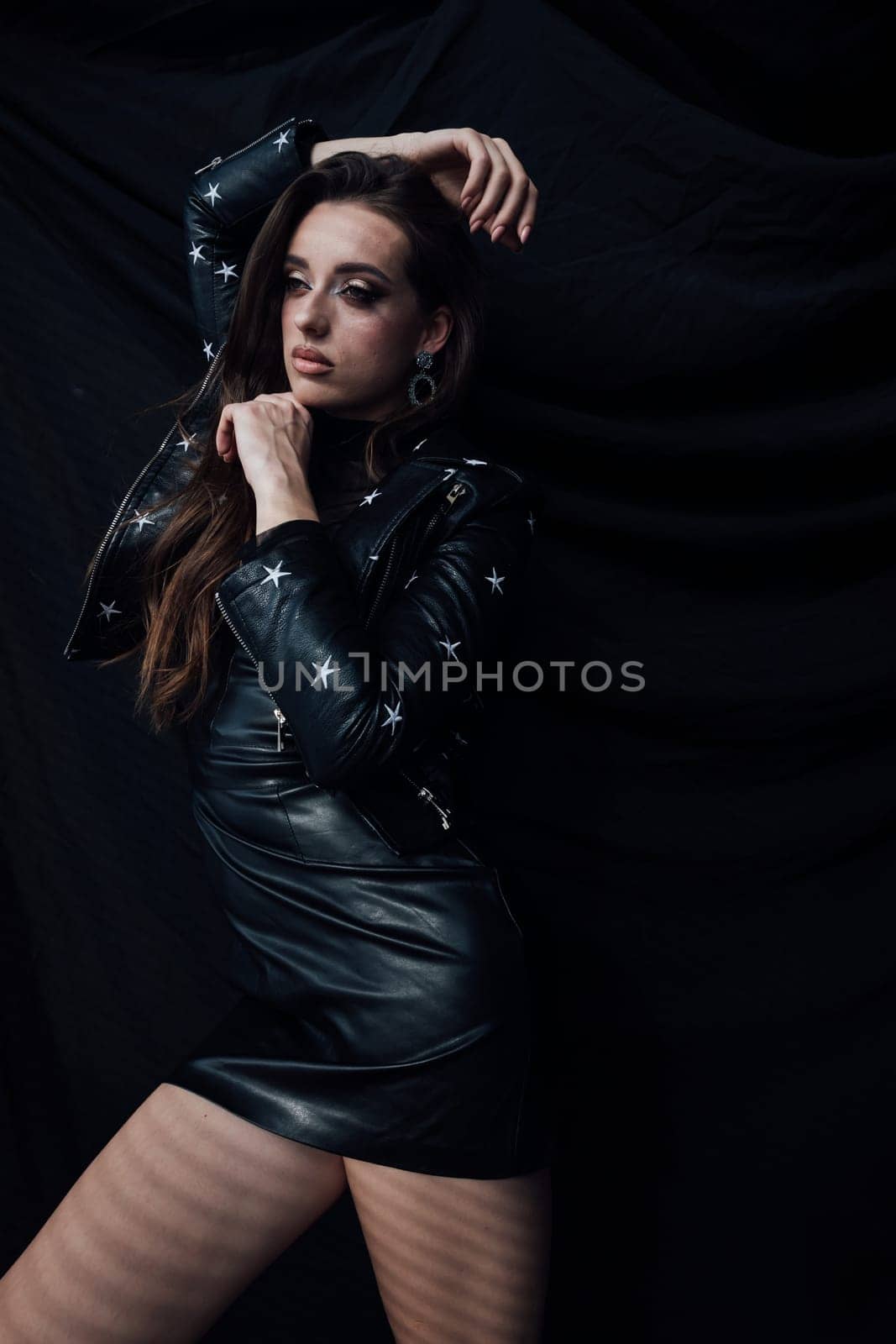 Portrait of a beautiful fashionable woman in a black leather dress by Simakov