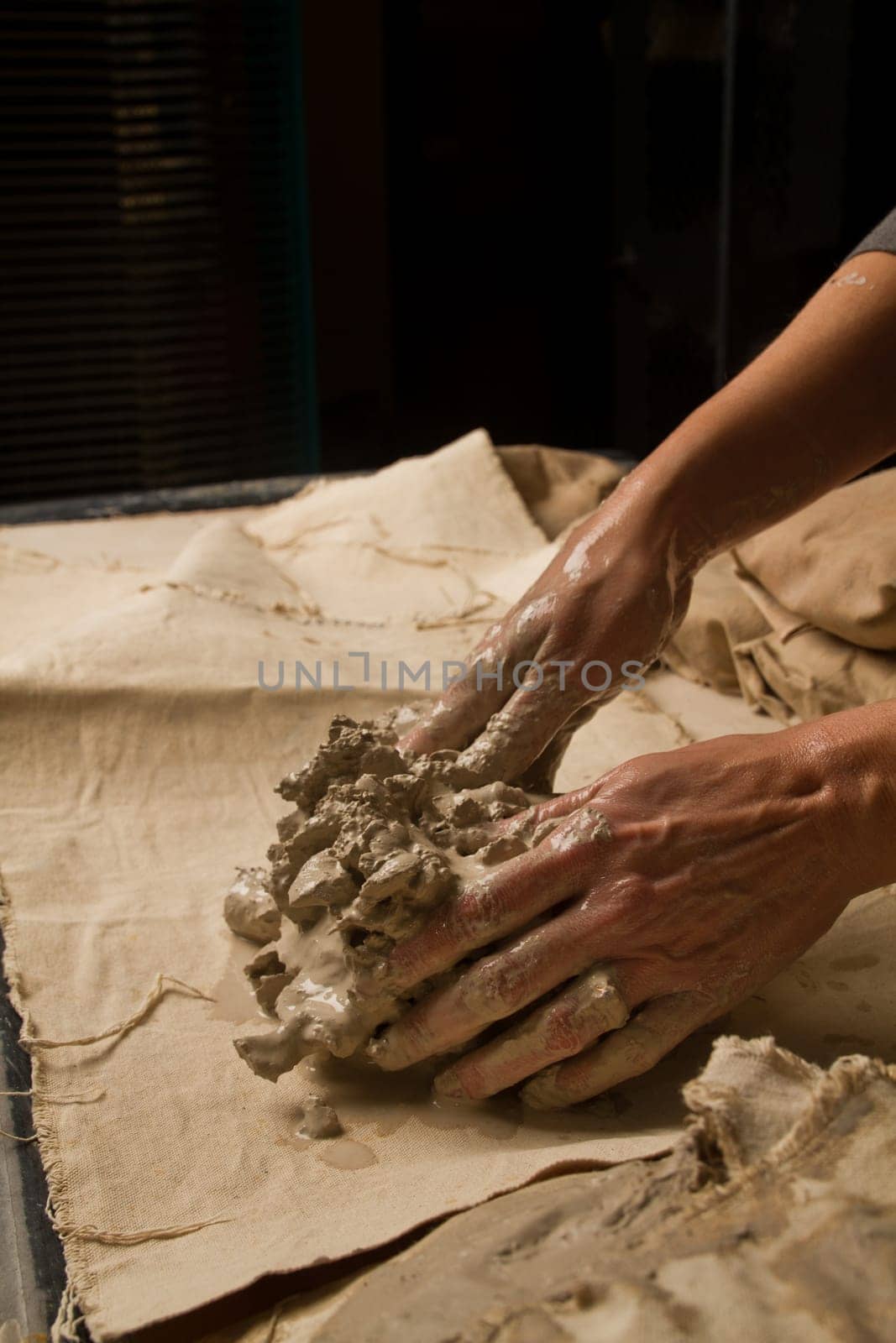 Craftsman shaping wet clay for pottery creation in Fort Wayne, Indiana studio