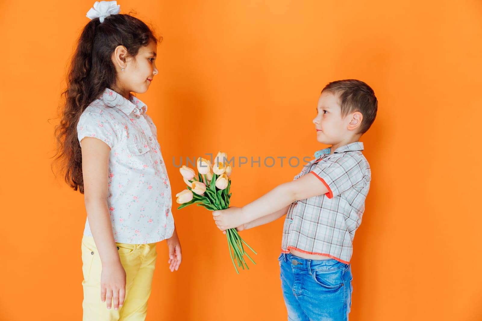 Little boy giving girl flowers with love by Simakov