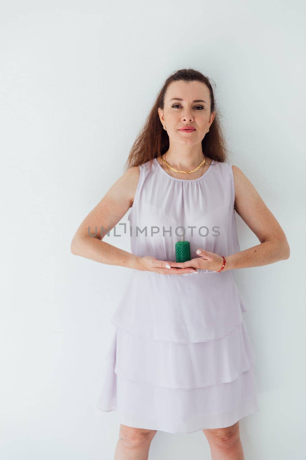 woman holding a green candle in her hands