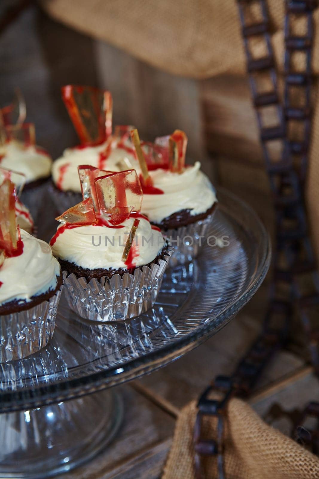 Gourmet Chocolate Cupcakes with Red Glass Candy in Rustic Setting by njproductions