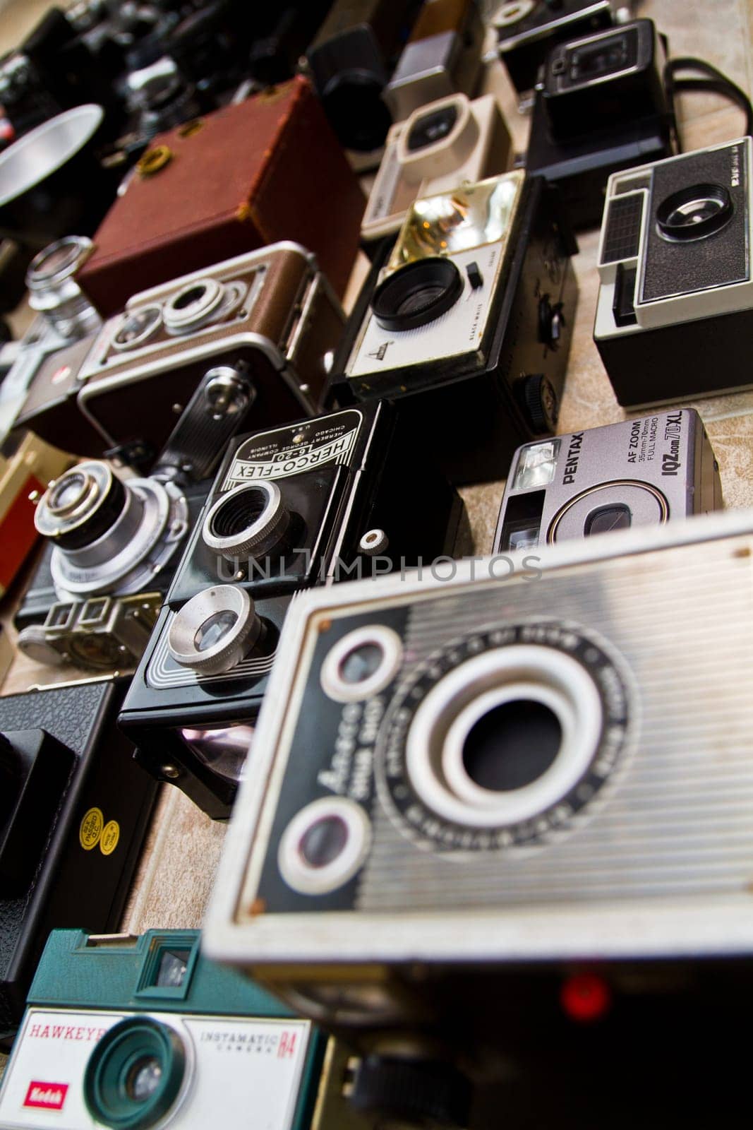 Vintage Camera Collection: A stunning assortment of nostalgic film cameras, including box, folding, and point-and-shoot models, displayed in a haphazard arrangement. From Fort Wayne, Indiana.