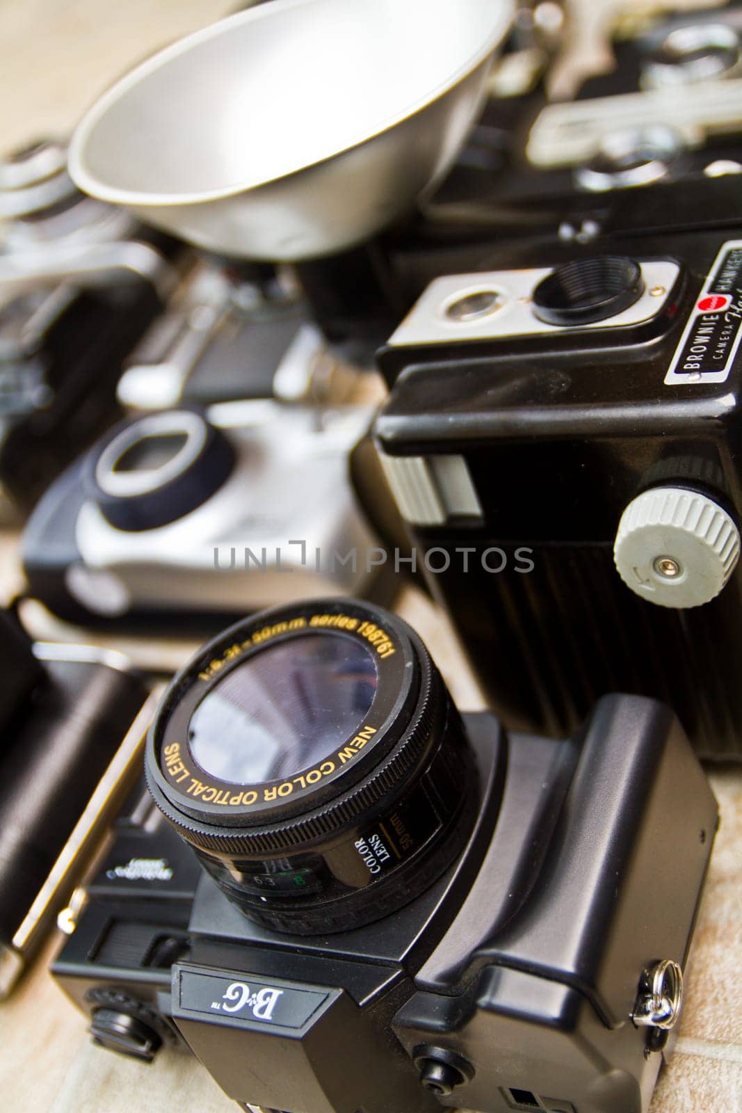 Vintage 35mm SLR Camera with Auto Optic Lens and Photography Equipment on Textured Surface - Nostalgia, History of Photography, Vintage Technology