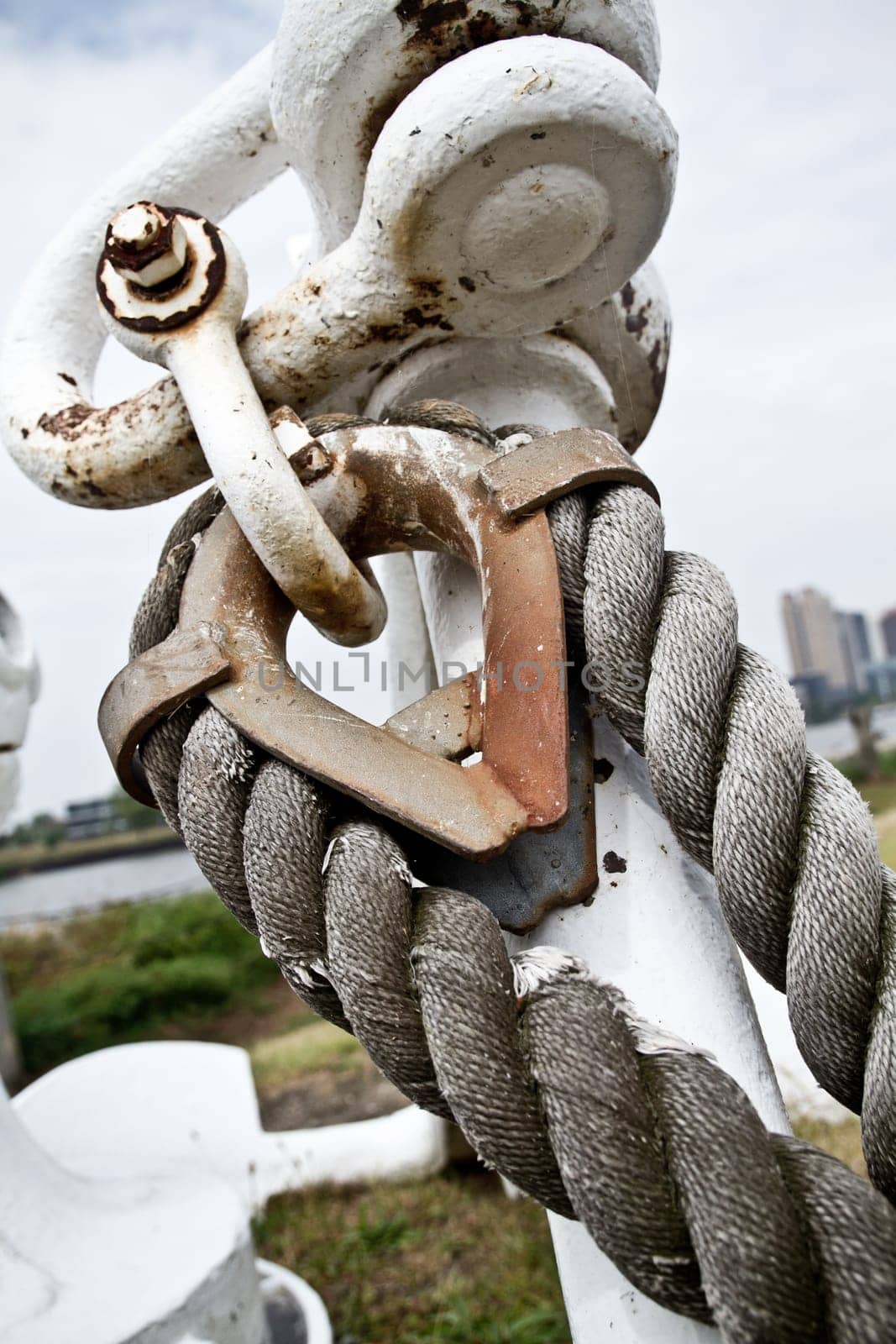 Weathered Mooring Bollard and Steel Rope in Maritime Setting Close-Up by njproductions