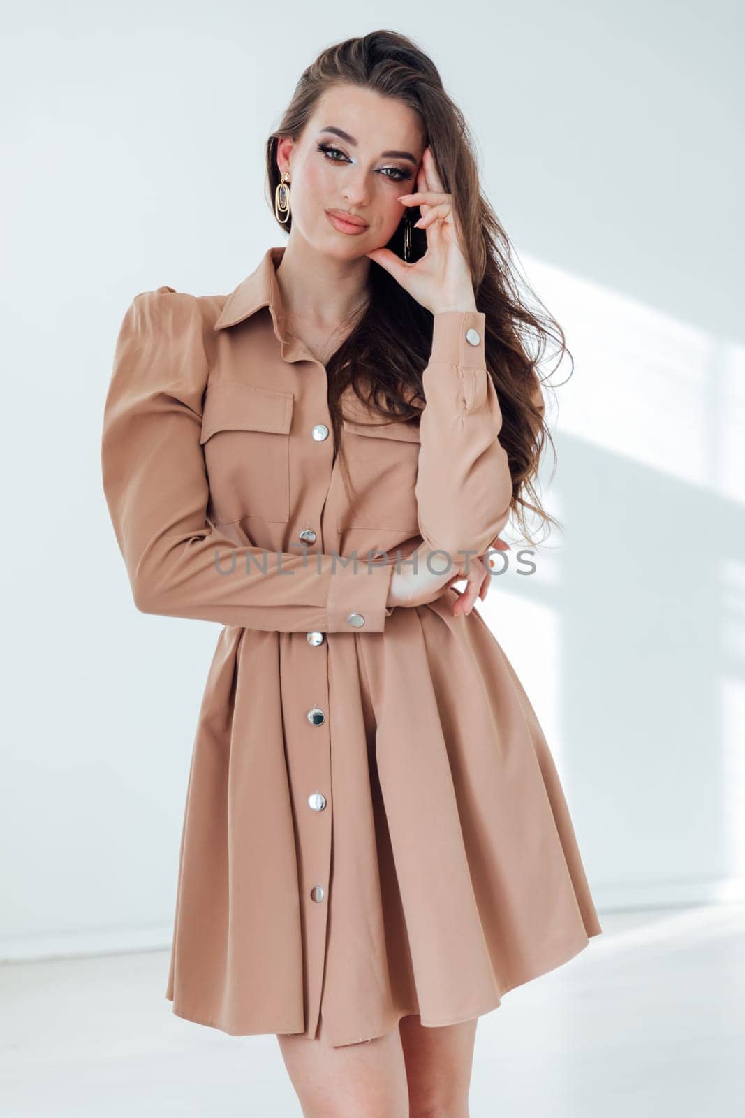 Portrait of a beautiful young woman in a summer beige dress