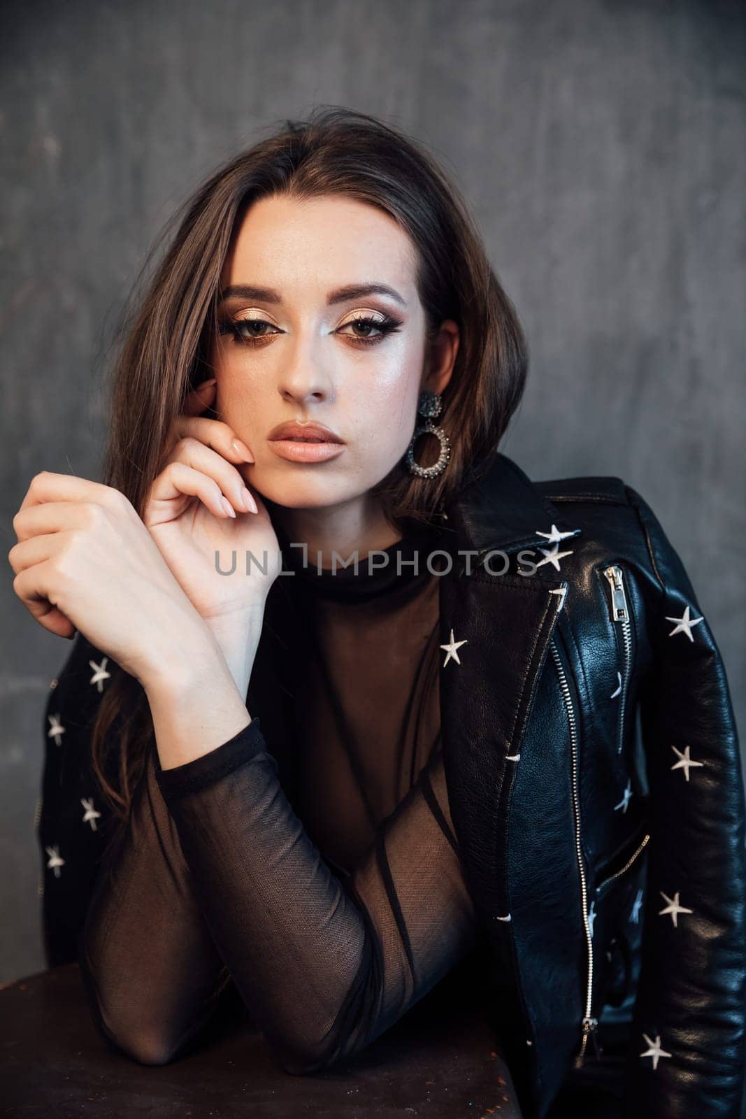 Portrait of a beautiful fashionable woman in a black leather dress by Simakov