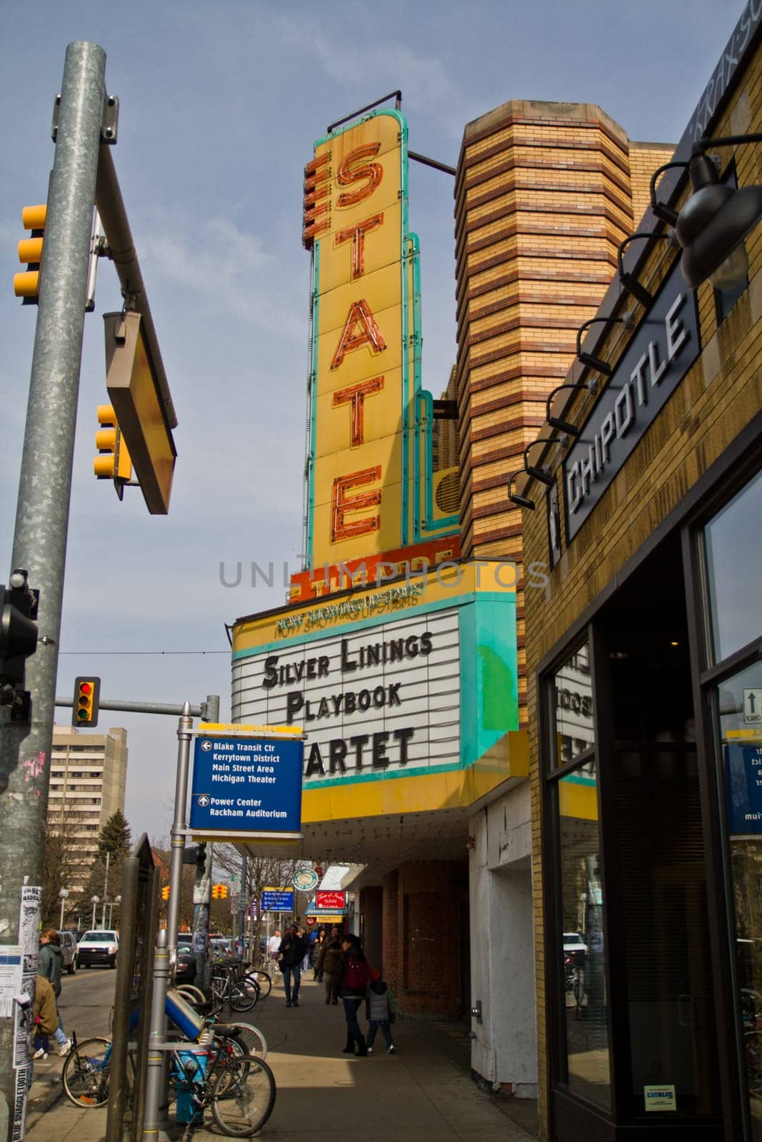 Experience the vibrant blend of history and modernity in downtown Ann Arbor, MI. The iconic 'STATE' theater marquee shines bright, promoting 'Silver Linings Playbook,' while Chipotle stands as a symbol of contemporary dining.