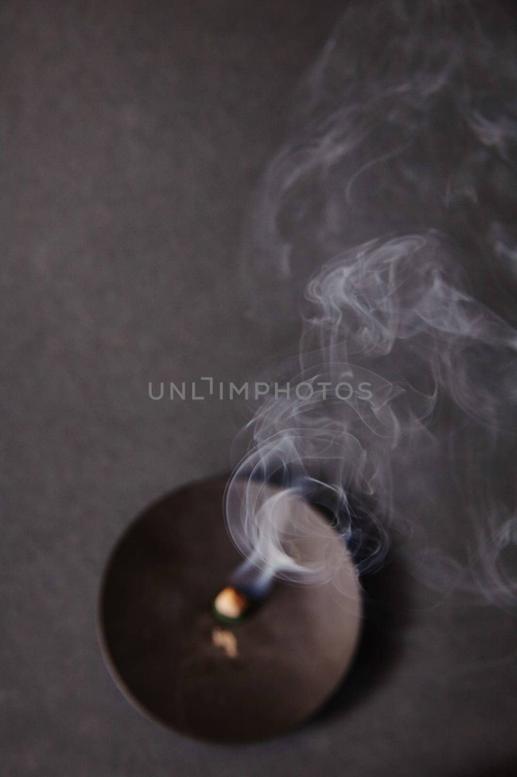 A serene scene from above of incense with wisps of smoke, symbolizing completion and fleeting inspiration.