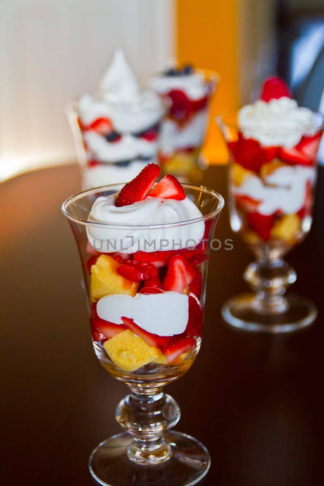Deliciously decadent strawberry shortcake desserts in glass cups, featuring layers of juicy red strawberries, golden cake cubes, and creamy whipped cream. Perfect for summer gatherings or special occasions.