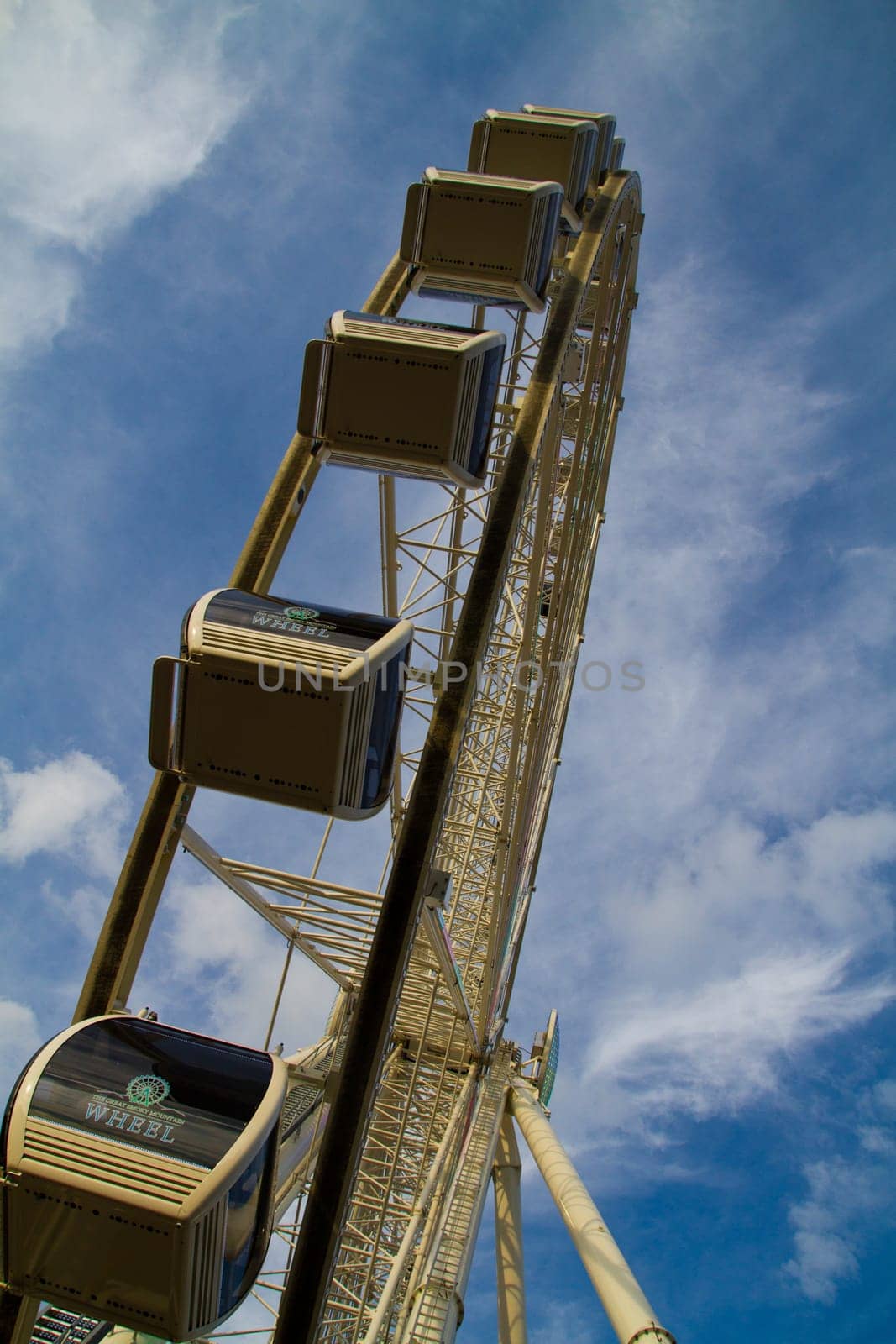 Enjoy the thrill of the towering Ferris wheel against a picturesque sky in Gatlinburg, Tennessee. This modern urban attraction offers panoramic views from its enclosed gondolas, providing the perfect backdrop for a joyful day of entertainment.
