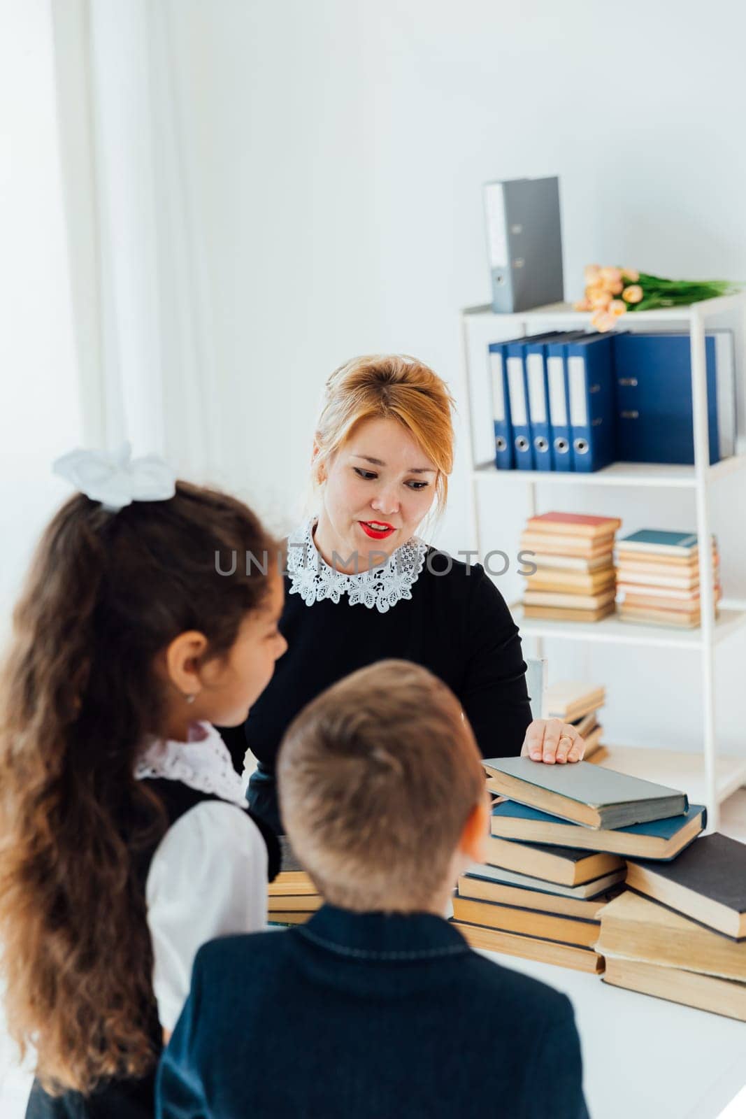 Teacher teaching children in school classroom by Simakov