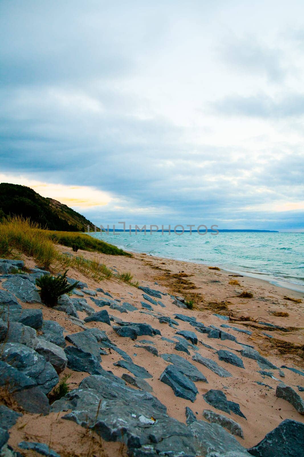 Tranquil dawn on a serene beach along Lake Michigan's rocky shoreline, offering a peaceful escape amidst nature's beauty. Perfect for travel and environmental themes.