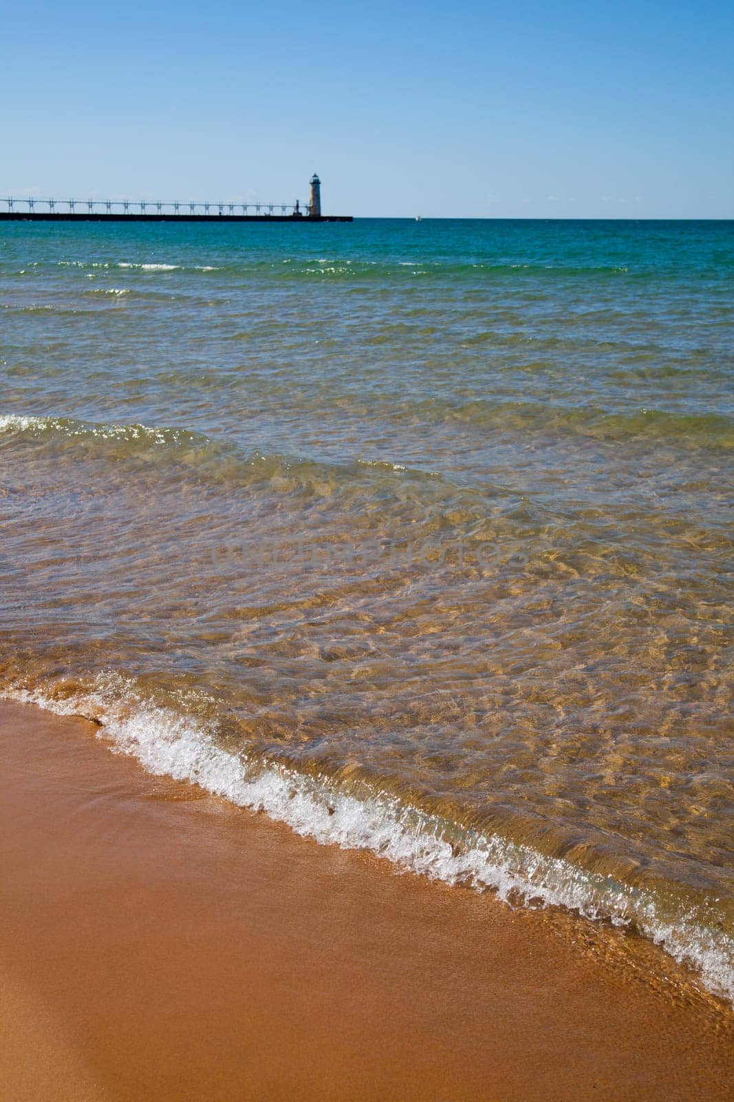Serene Lake Michigan Shoreline with Golden Sand and Classic Lighthouse by njproductions