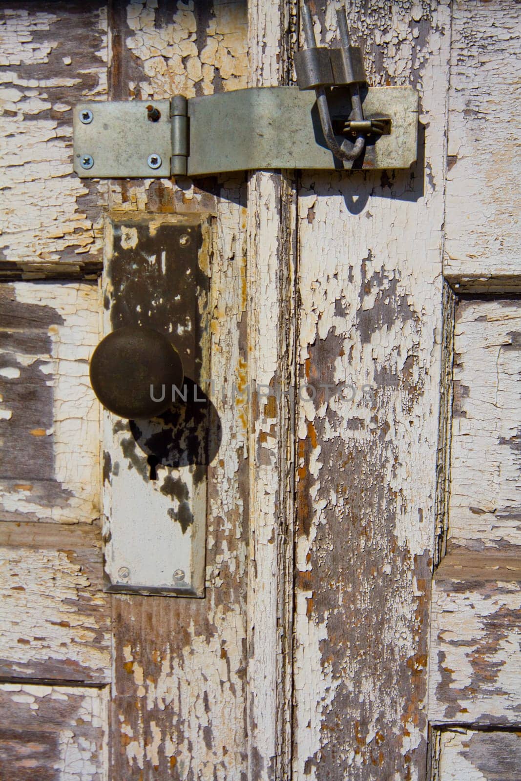 Close-up of Rusty Padlock on Aged Wooden Door at Abandoned Auburn Electric Station, Indiana - A Study in Texture, Decay and Time. Chipped white paint on wooden door.